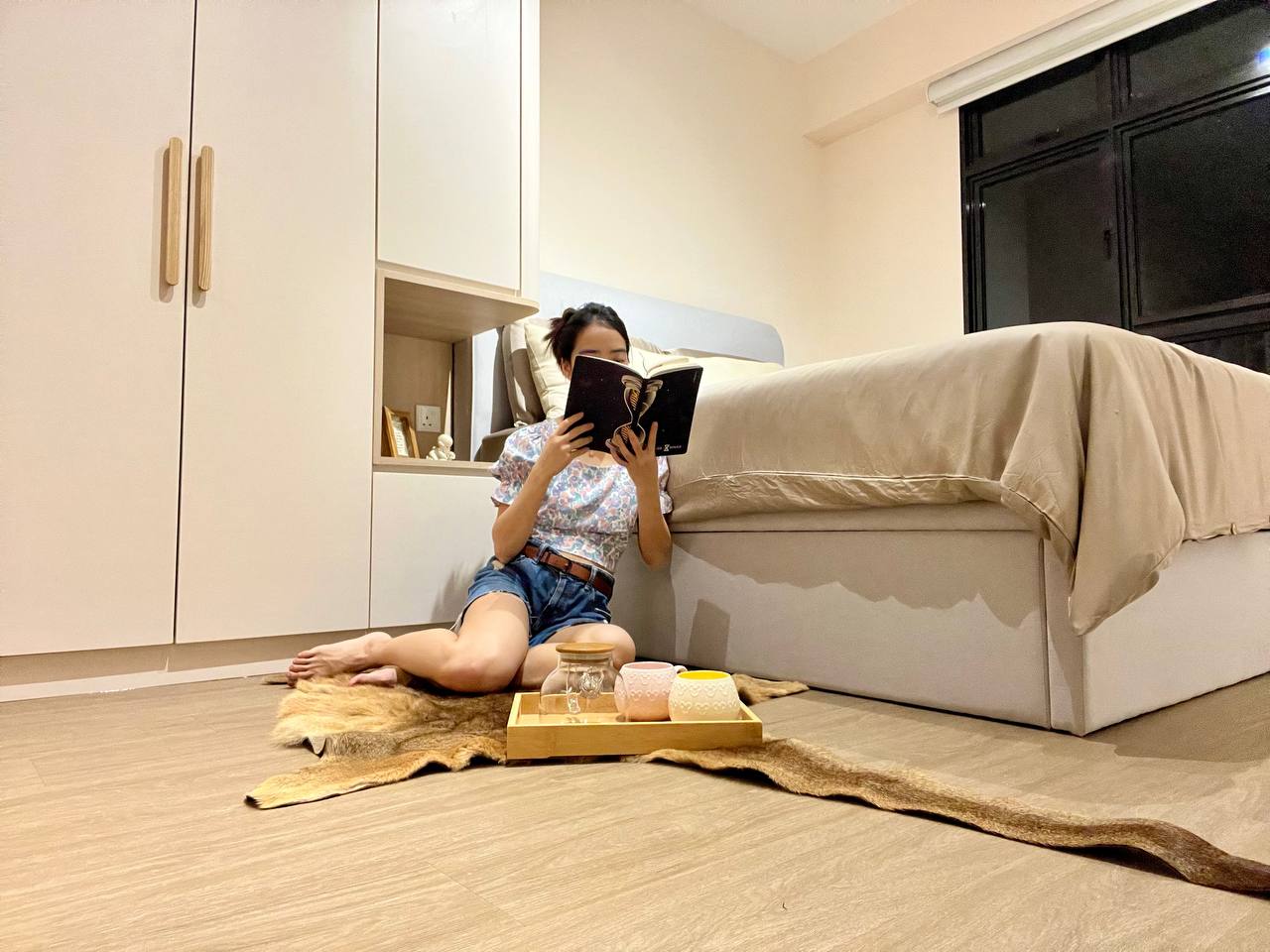 Master Bedroom: Going Basic with a Near Monochromatic Look - Young woman reading book on floor, cozy bedroom setting