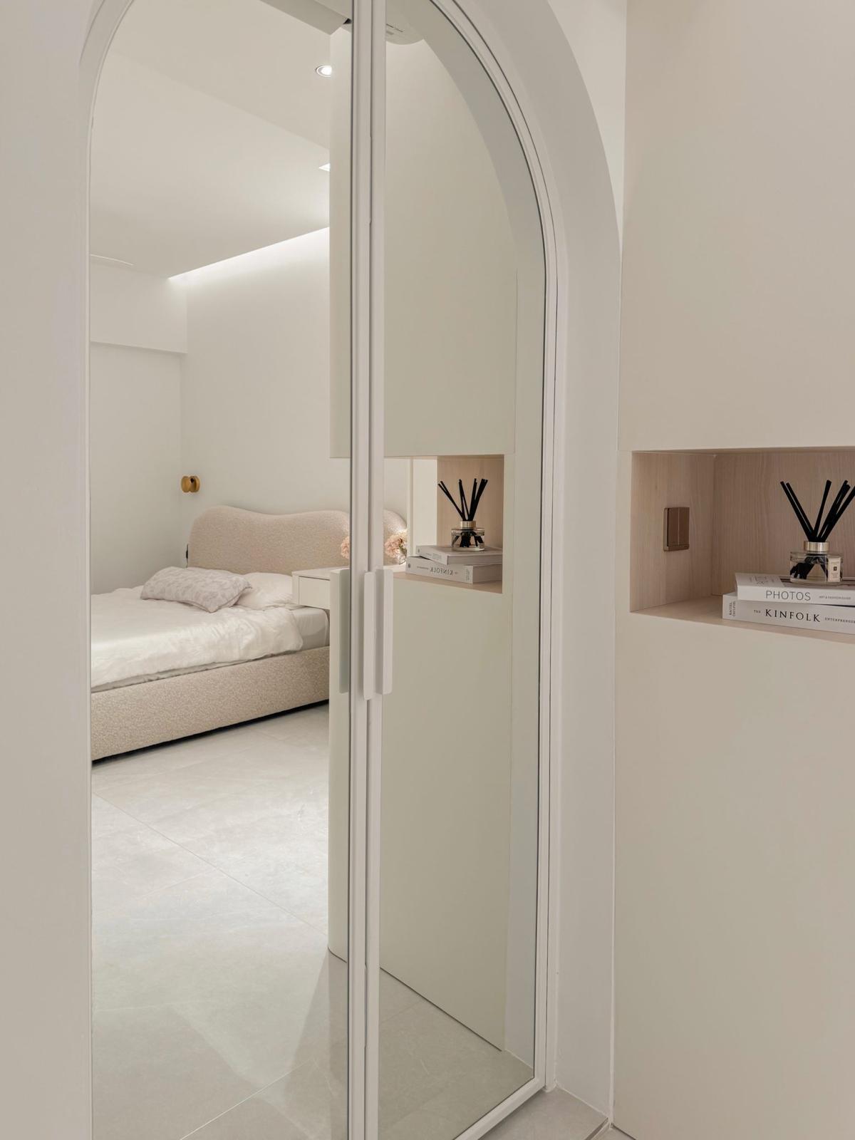 Our Master Bedroom: Smart, Calming & Curvy (with a mirror-ed door!) - Minimalist bedroom with sleek white cabinets, soft