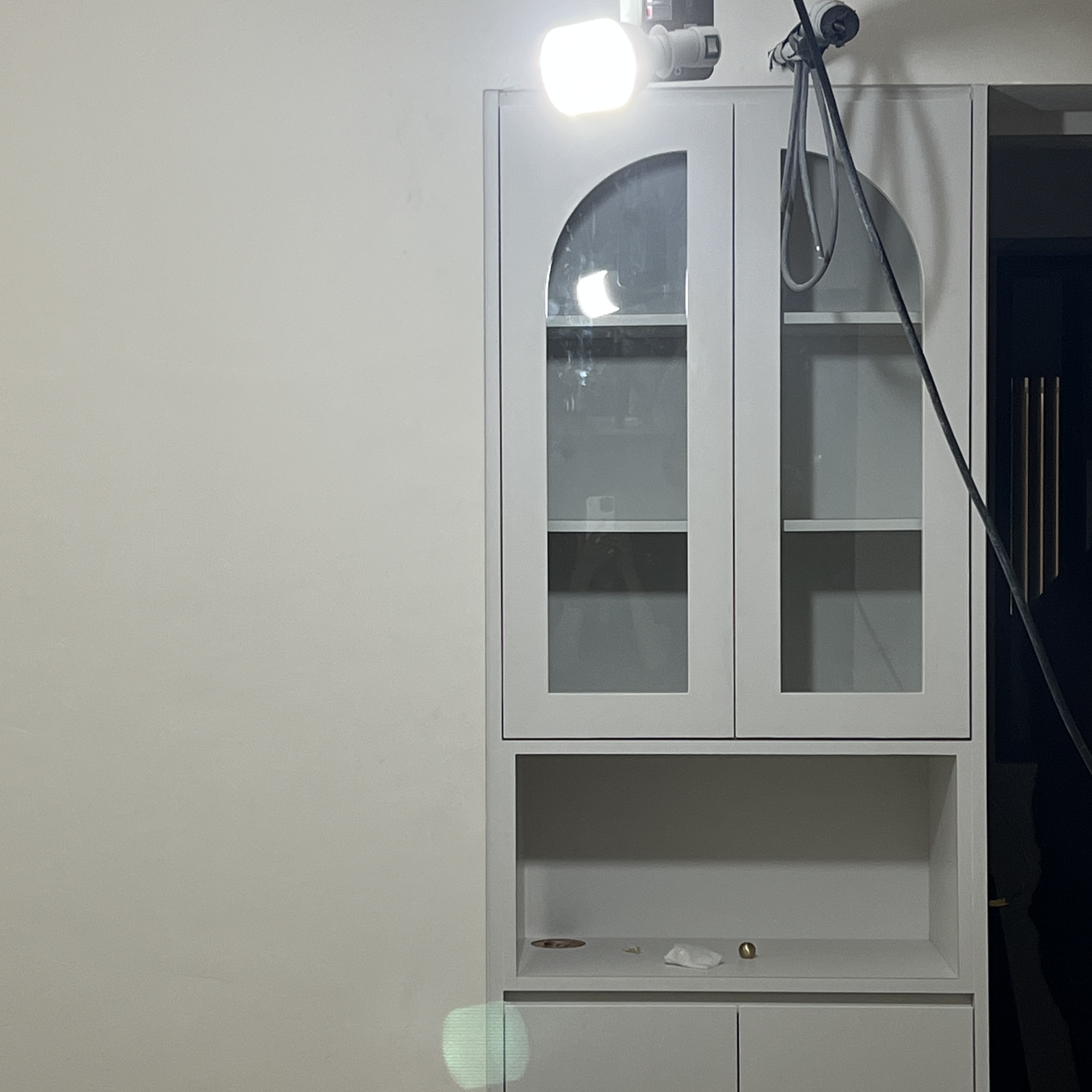 Our Comfy Bedroom for Relaxing Nights - White cabinet with glass doors, illuminated by bright light, empty shelves, modern