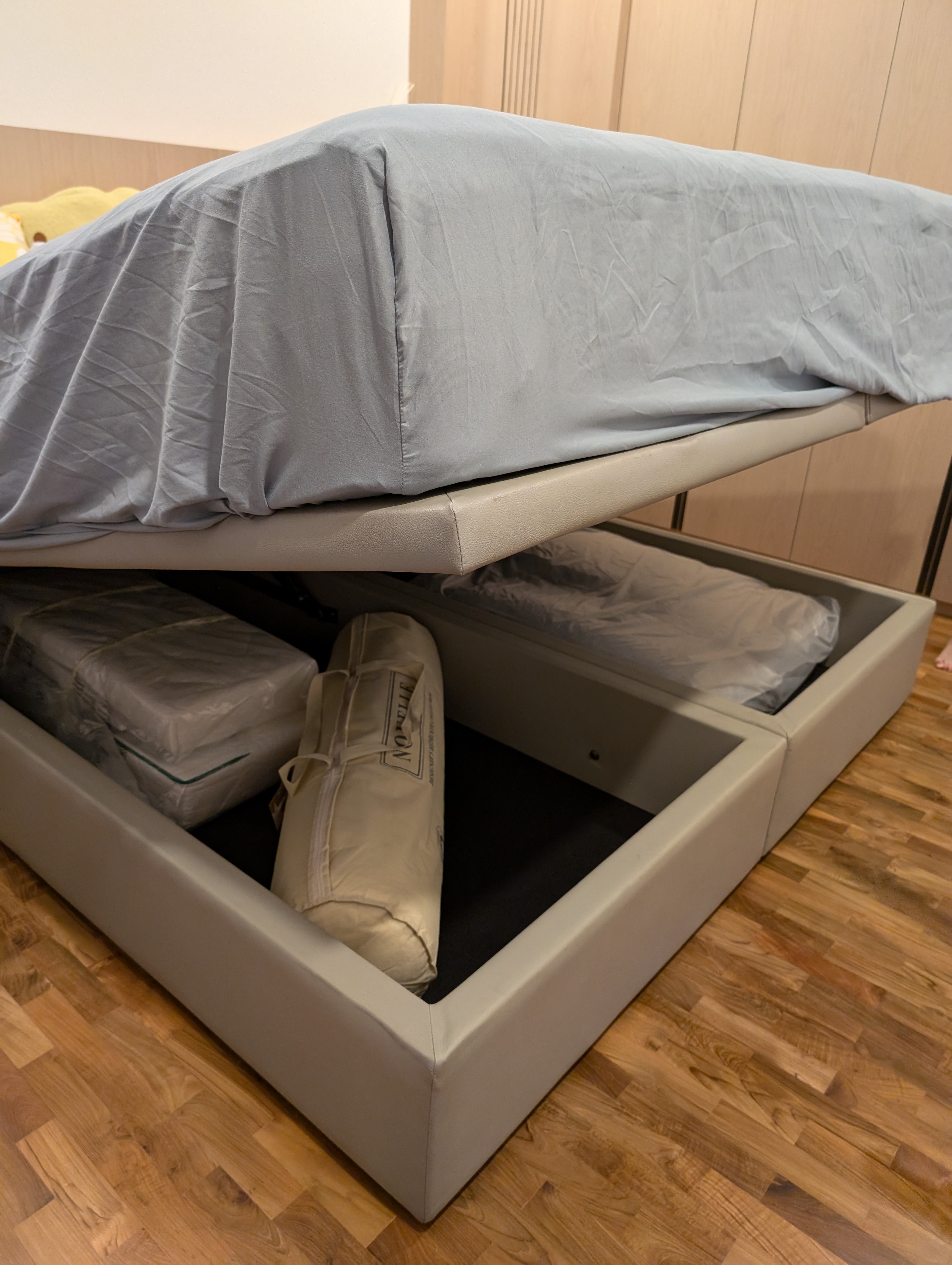 Spending the night with some curves 🍑 - Beds with gray and beige covers, wooden floor, neatly folded blankets, storage