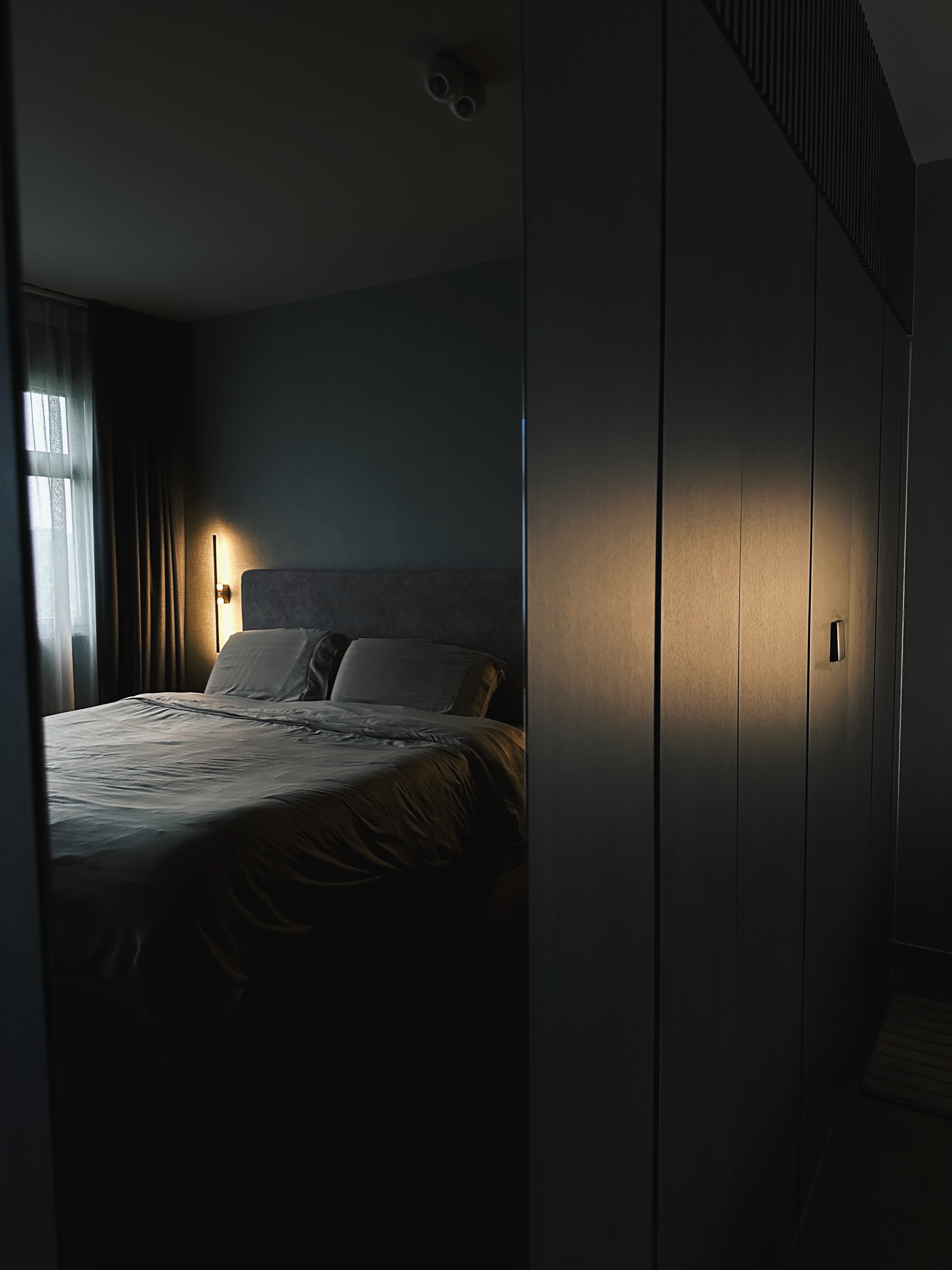 Finding Comfort: A Glimpse into Our Cozy and Minimalist Bedroom - dimly lit bedroom, modern decor, dark gray bedding, plush