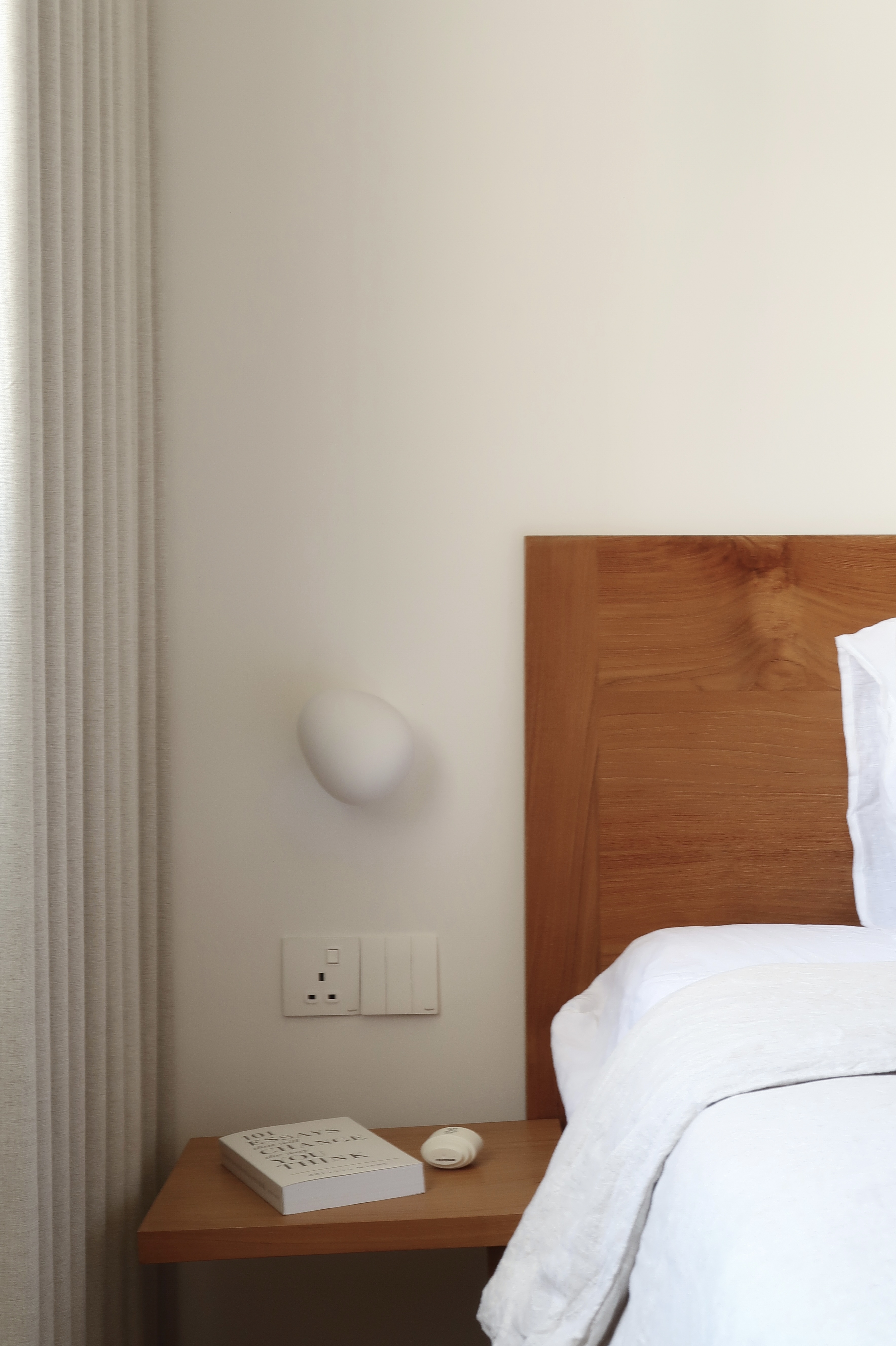 Master Bedroom: A Peaceful Retreat - White wall, minimalist design, wooden headboard, bedside table, white book, textured