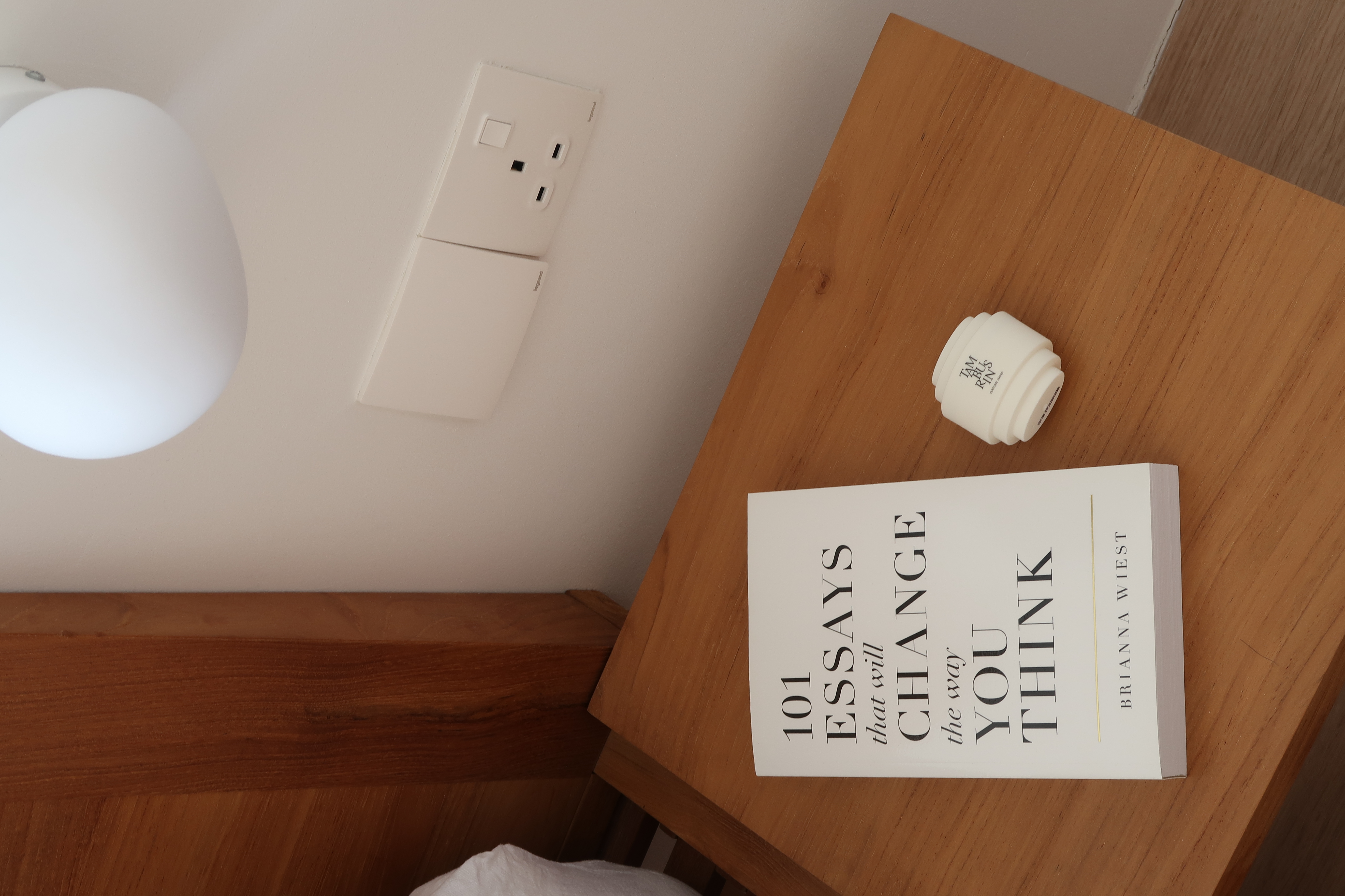 Master Bedroom: A Peaceful Retreat - Minimalistic bedroom corner with a modern lamp and wooden table, Book titled "101