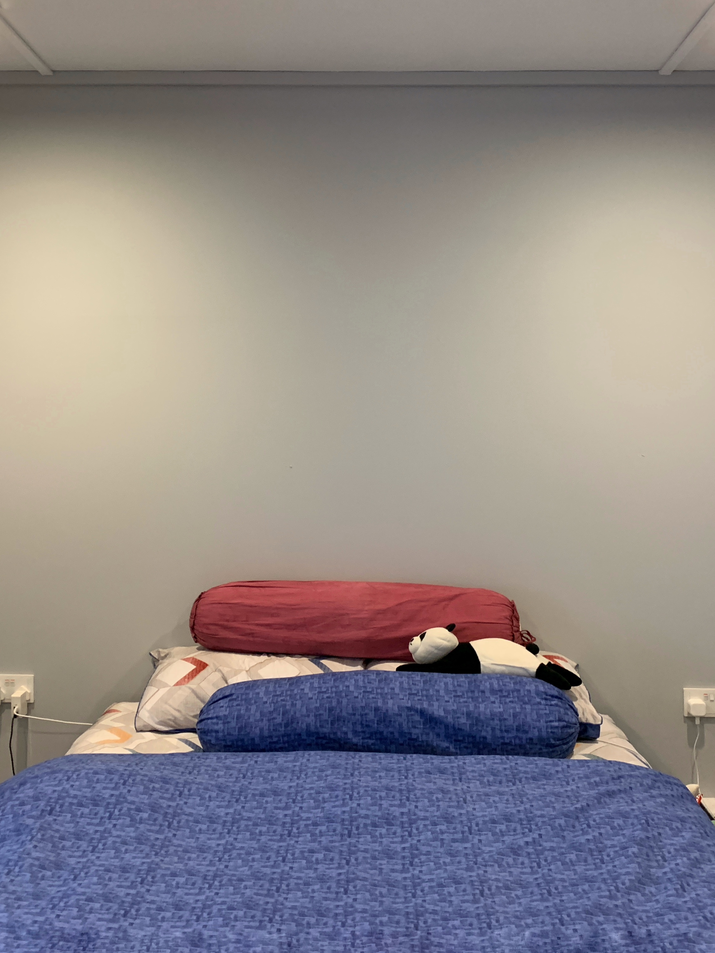 Transforming Our Bedroom from Minimal to Cosy  - Bed with blue and red bedding, featuring a plush panda toy., Minimalist