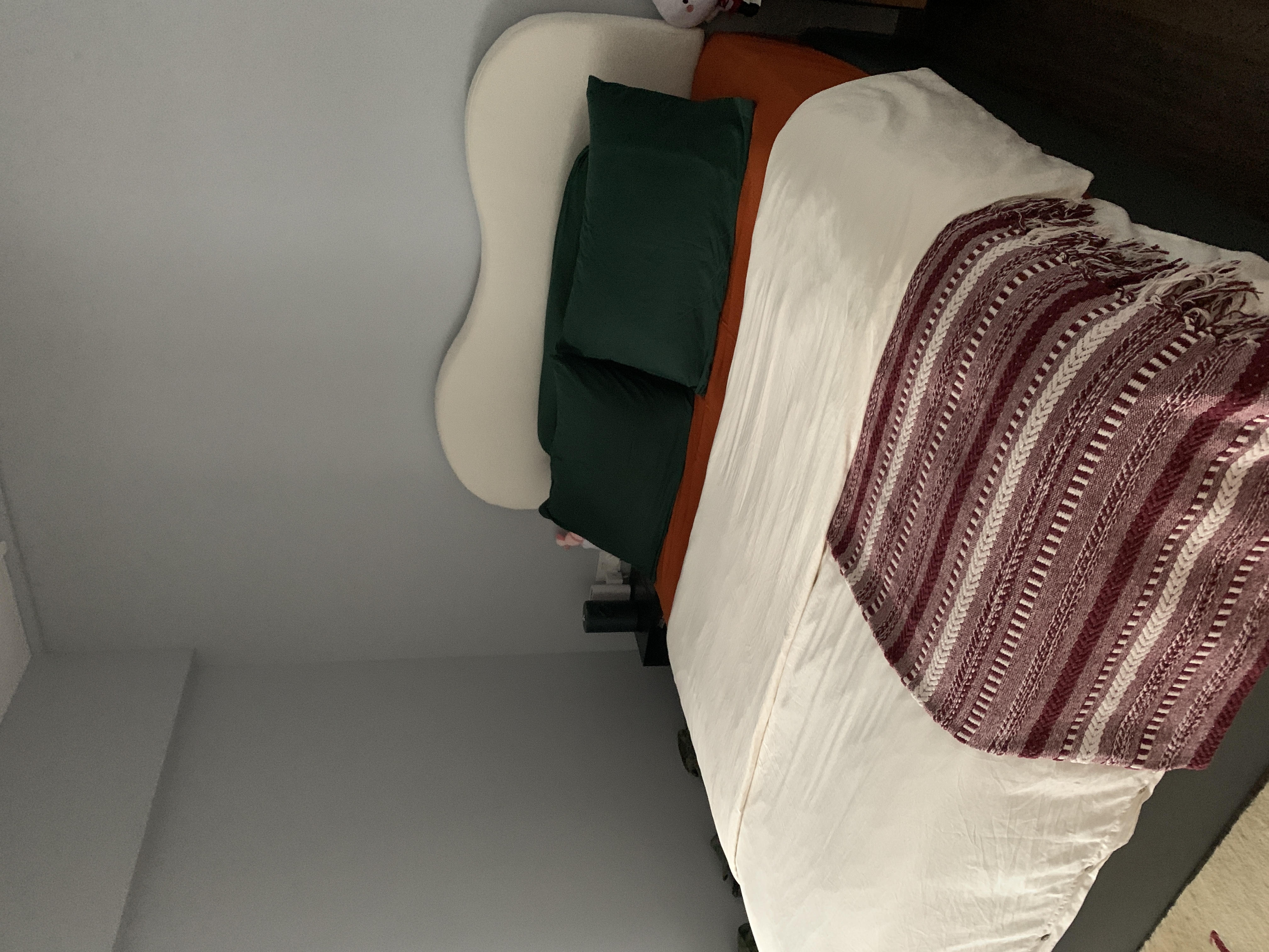 Transforming Our Bedroom from Minimal to Cosy  - White headboard, green pillows, orange bedspread, maroon striped blanket