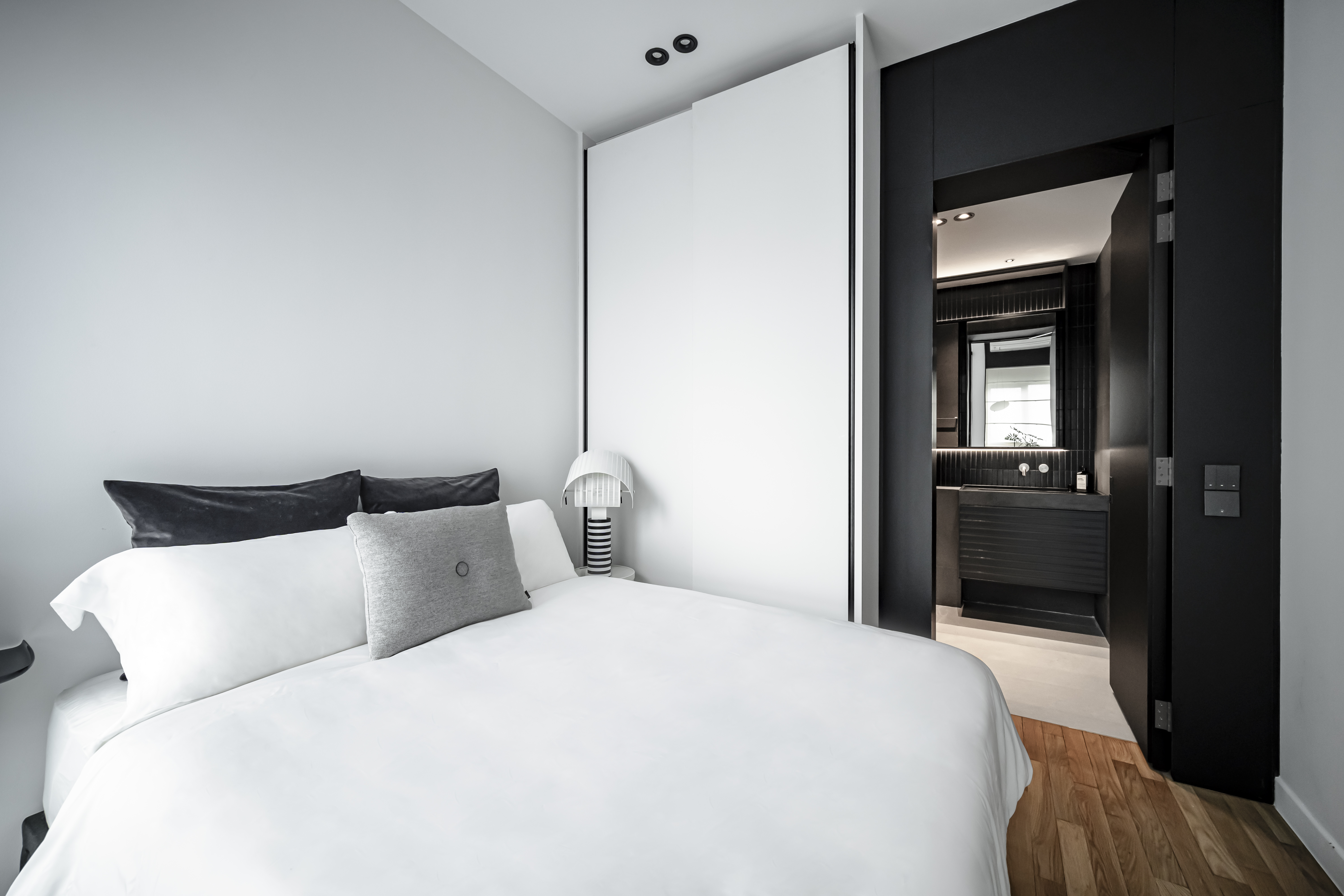 A Minimalistic Bedroom with Plenty of Storage Space  - Modern minimalist bedroom, sleek black and white decor, large bed with
