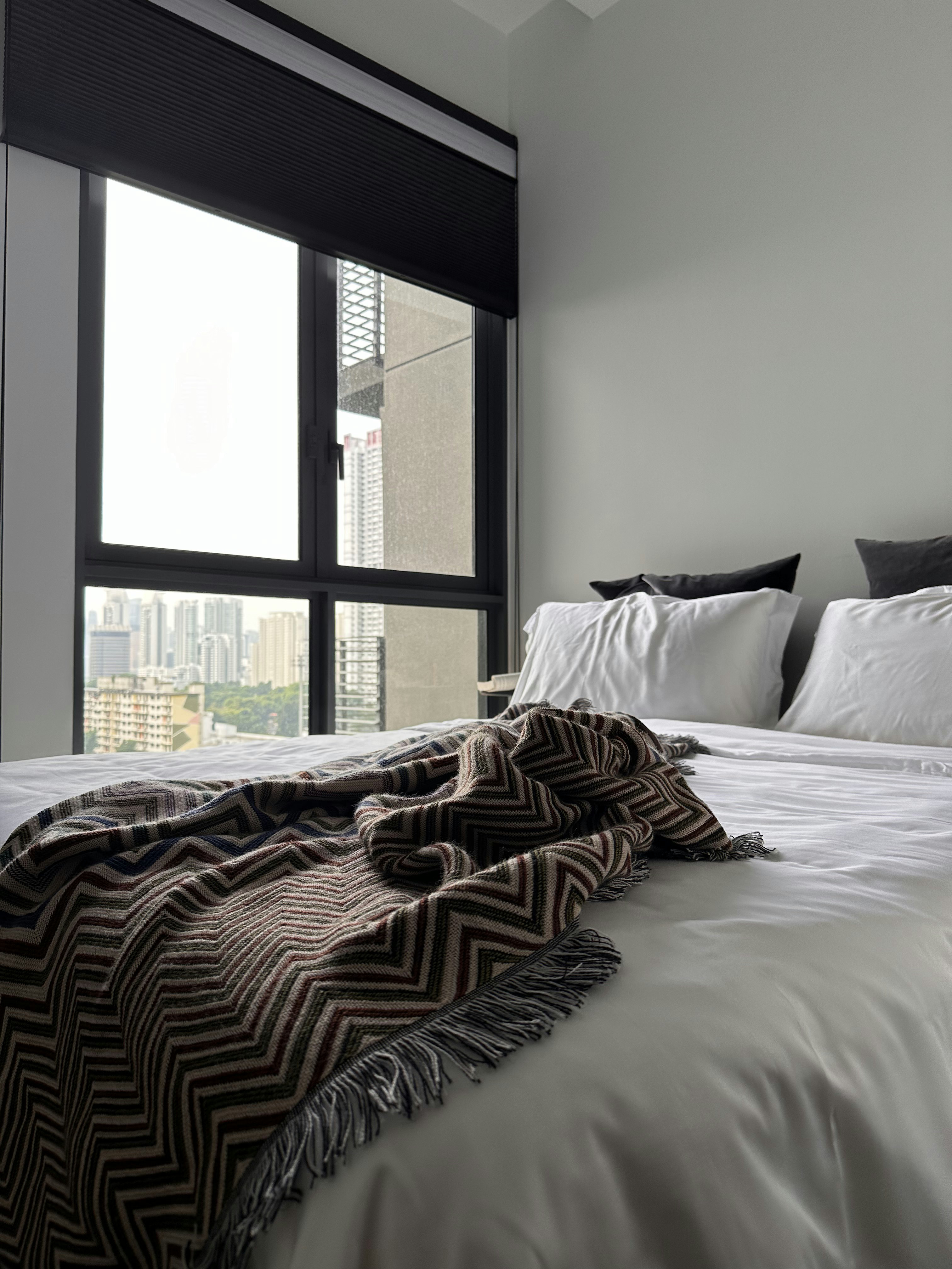 A Minimalistic Bedroom with Plenty of Storage Space  - Modern bedroom, large window, cityscape view, white bedding, black