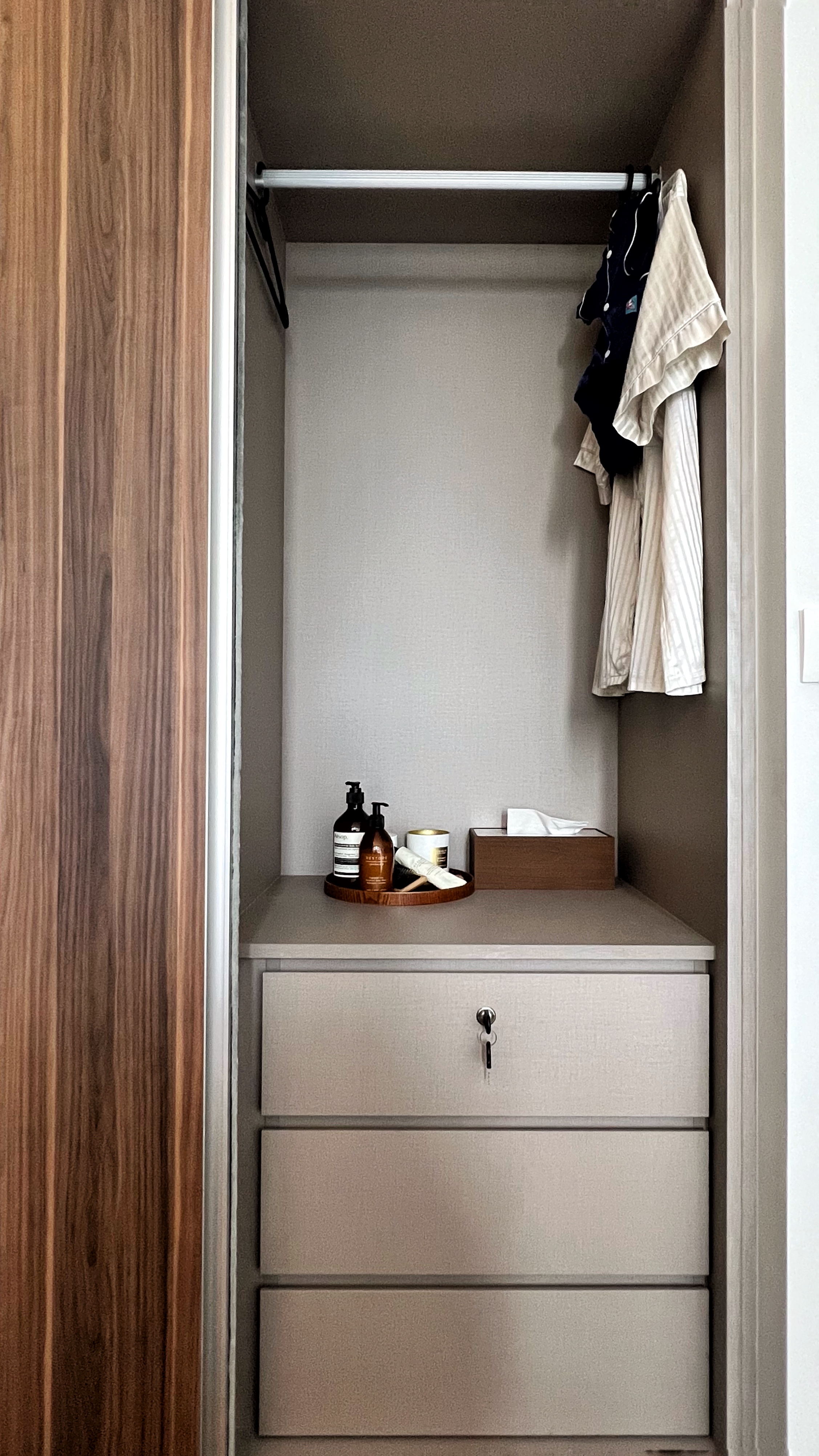 Unwind and Recharge: A Minimalist Yet Cosy Bedroom Retreat - Wooden door, open closet, beige walls, neatly organized, clothes