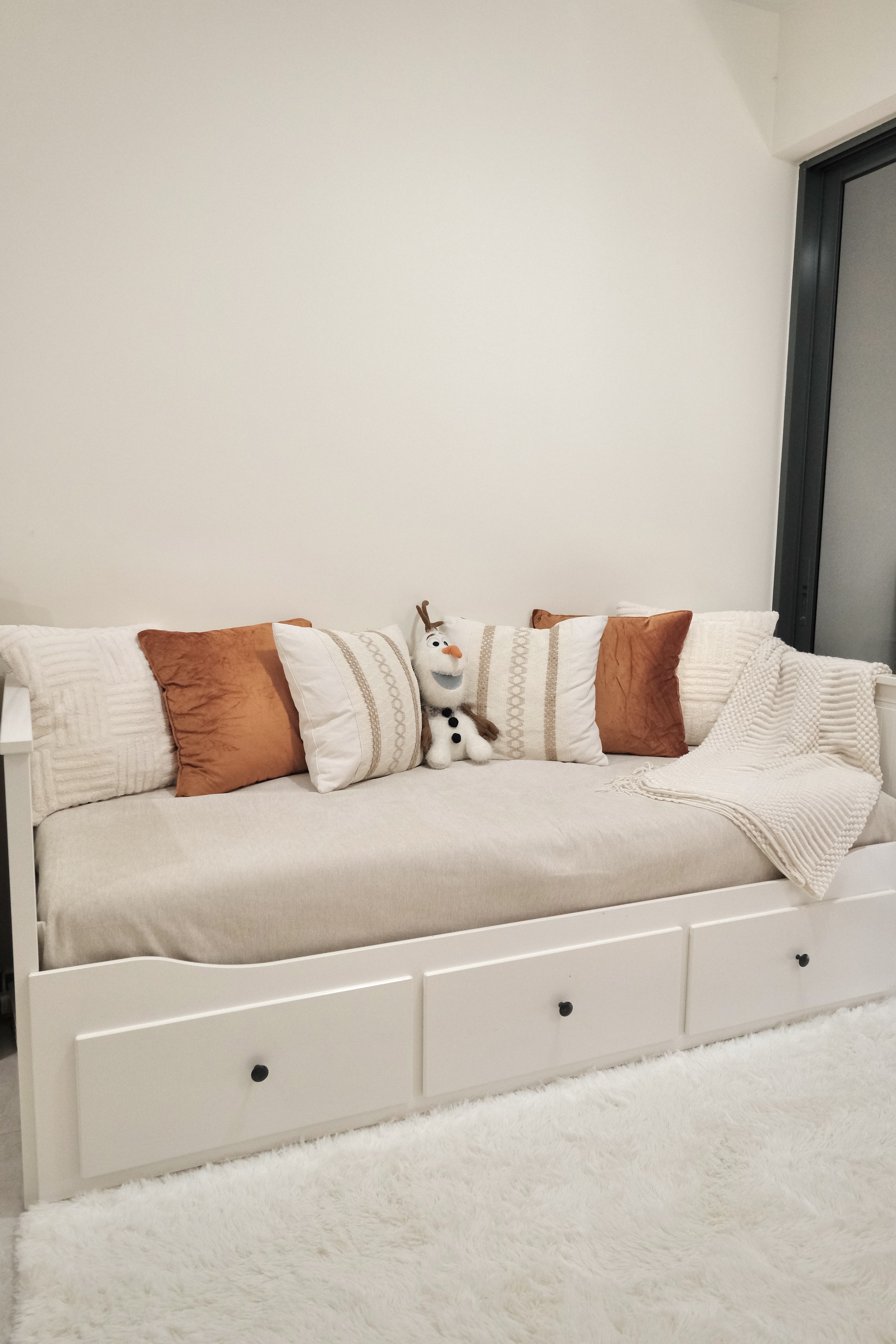 Here's why we can't leave this cosy living room! - White cozy sofa, plush cushions, reindeer toy, textured blanket