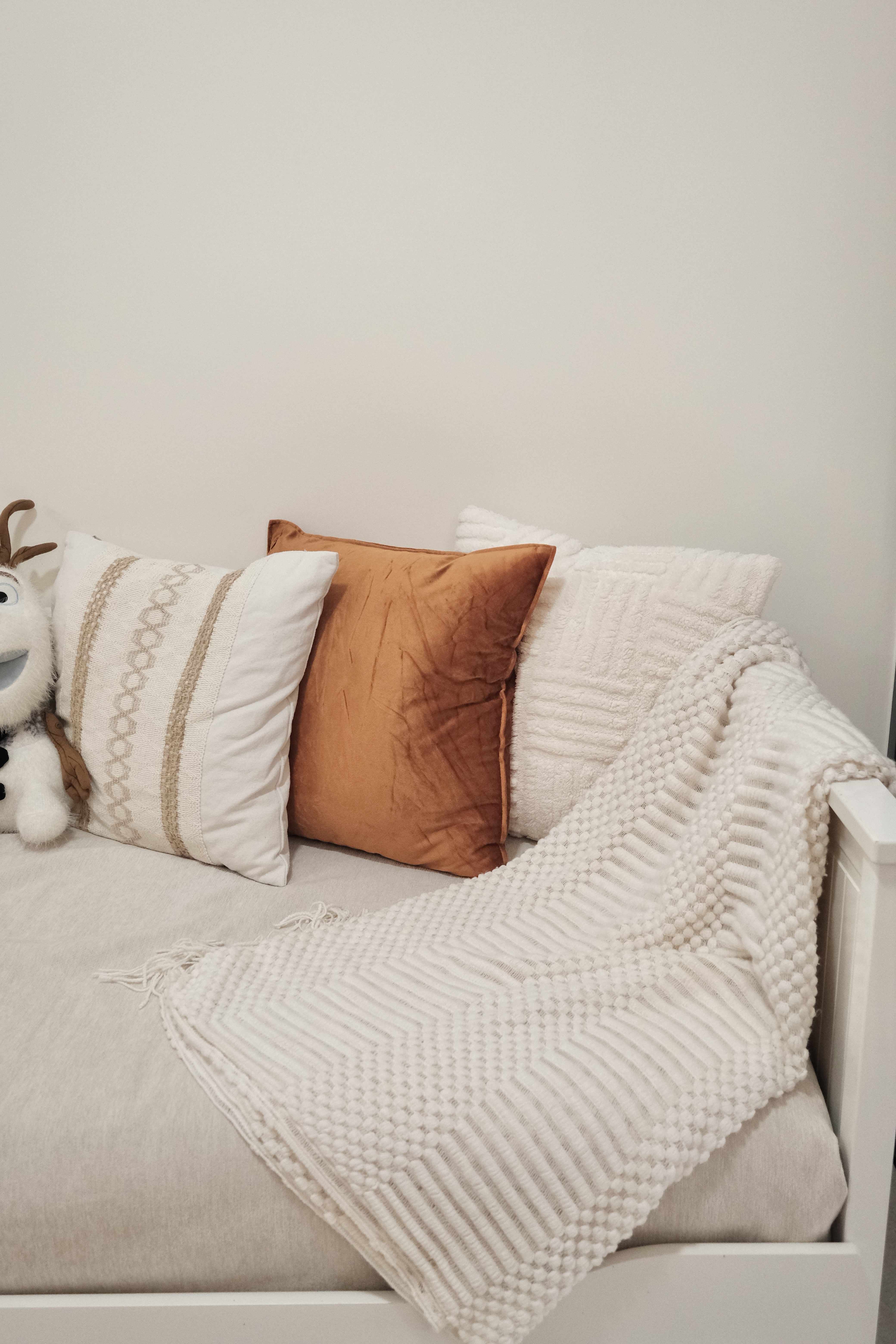 Here's why we can't leave this cosy living room! - White plush toy, brown pillow, beige and white striped pillow, textured
