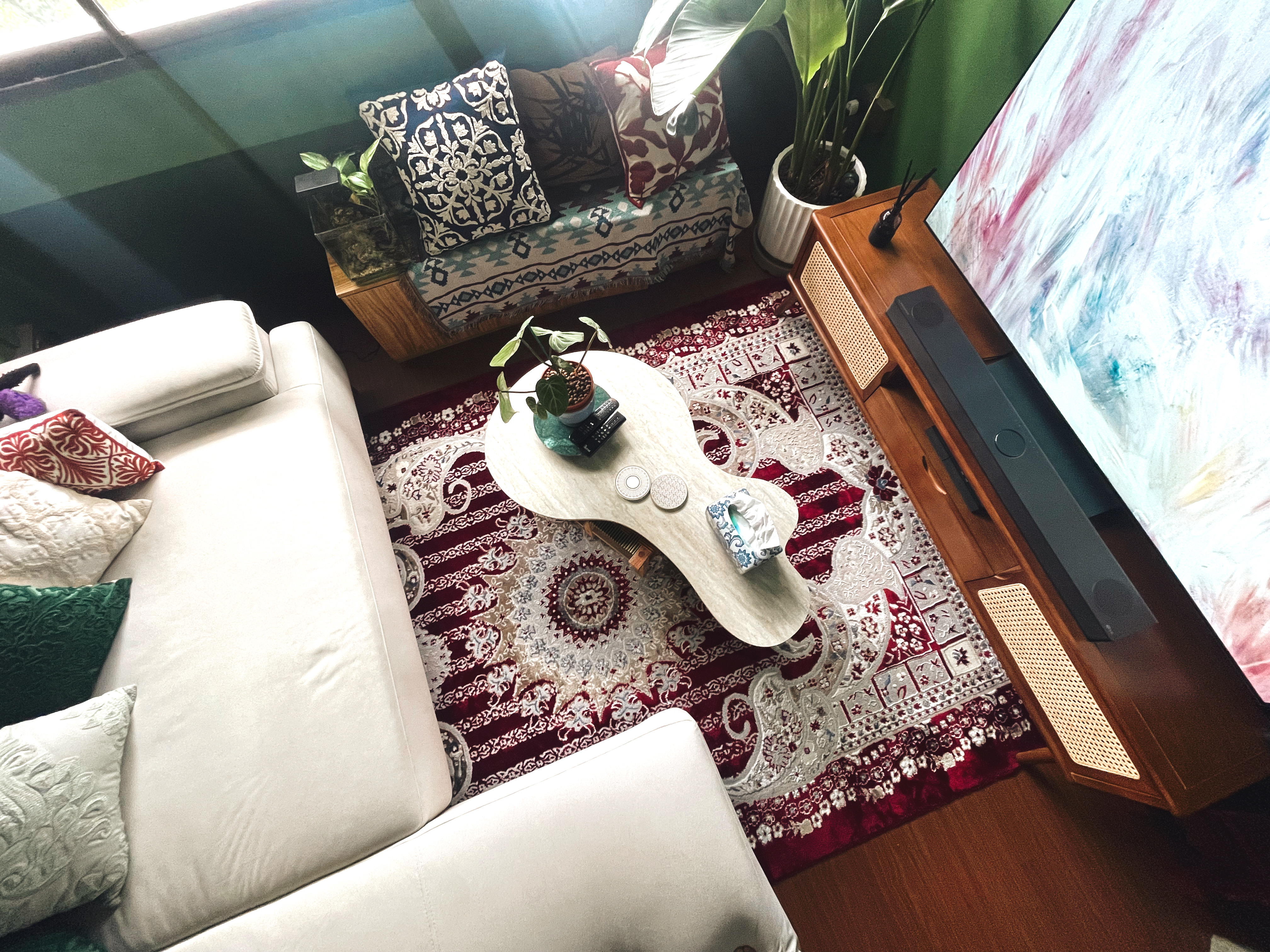 Curated Mix & Match: Our Living Room's Perfect Blend - Patterned cushions, green wall, wooden coffee table, textured rug