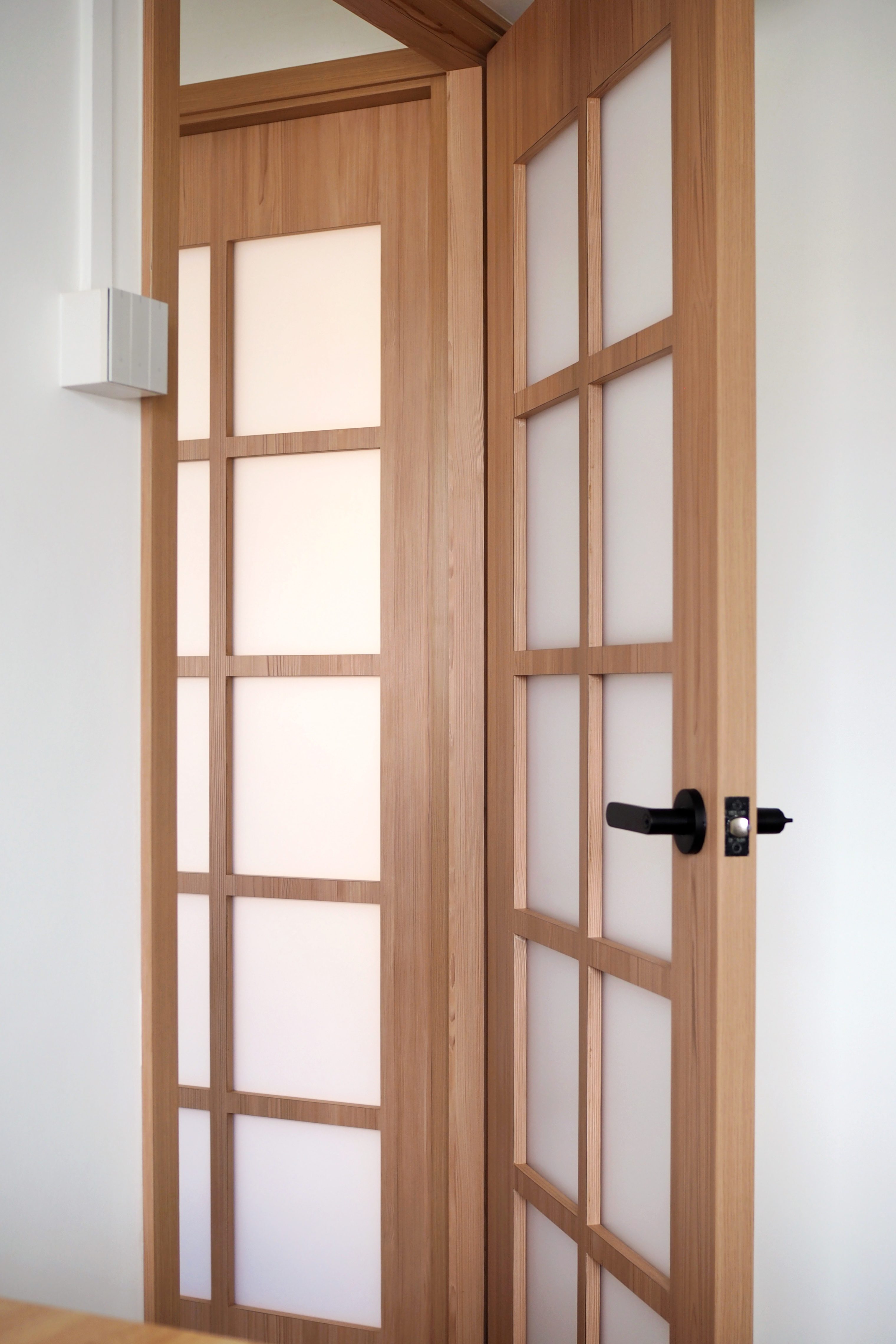 What nobody tells you about Japanese Shoji doors - Wooden door with frosted glass panels, white wall, modern design