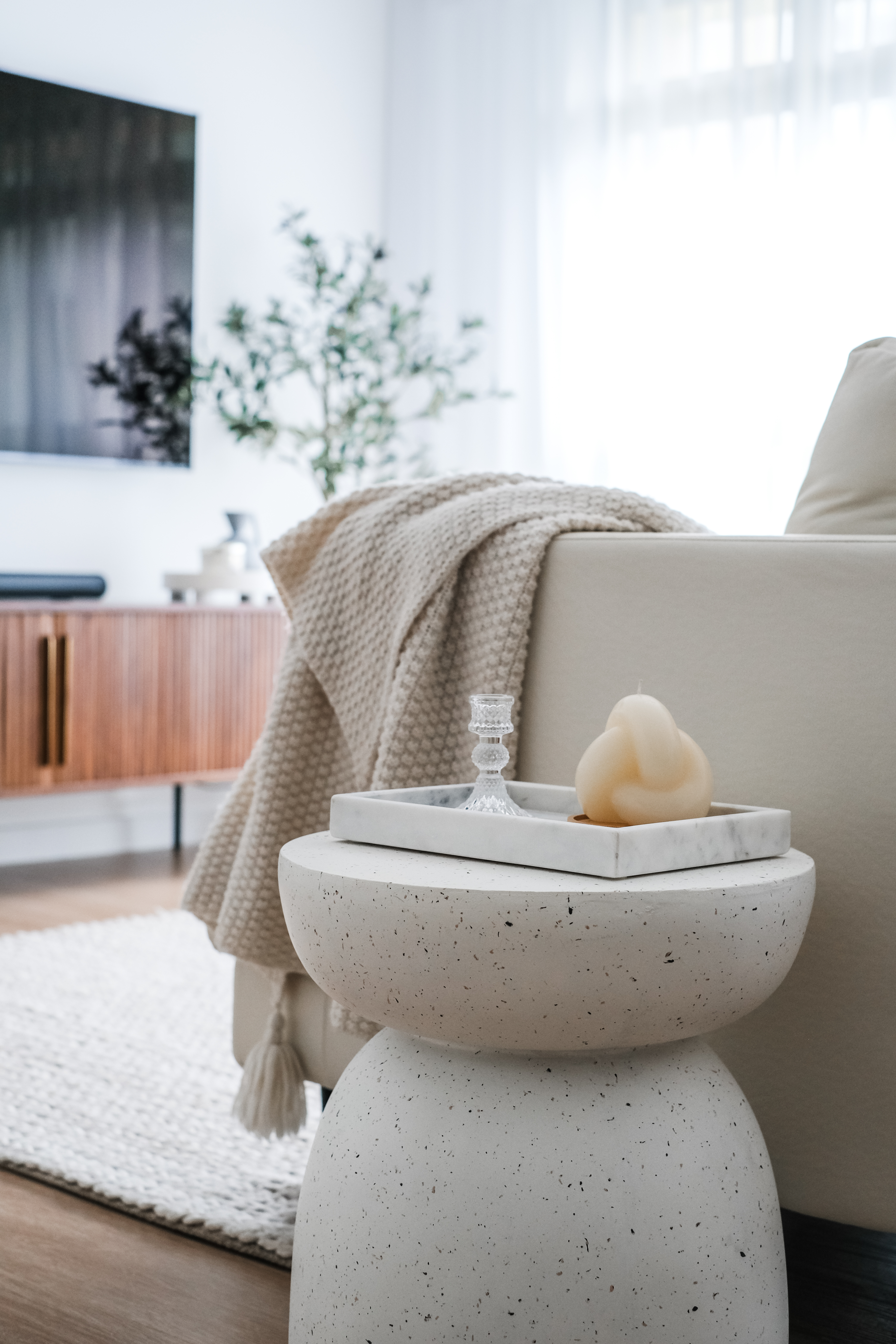 Comfort in Style: How $3.5k Loose Furniture Elevates CozyLiving Room - Cream-colored knitted blanket, marble tray with