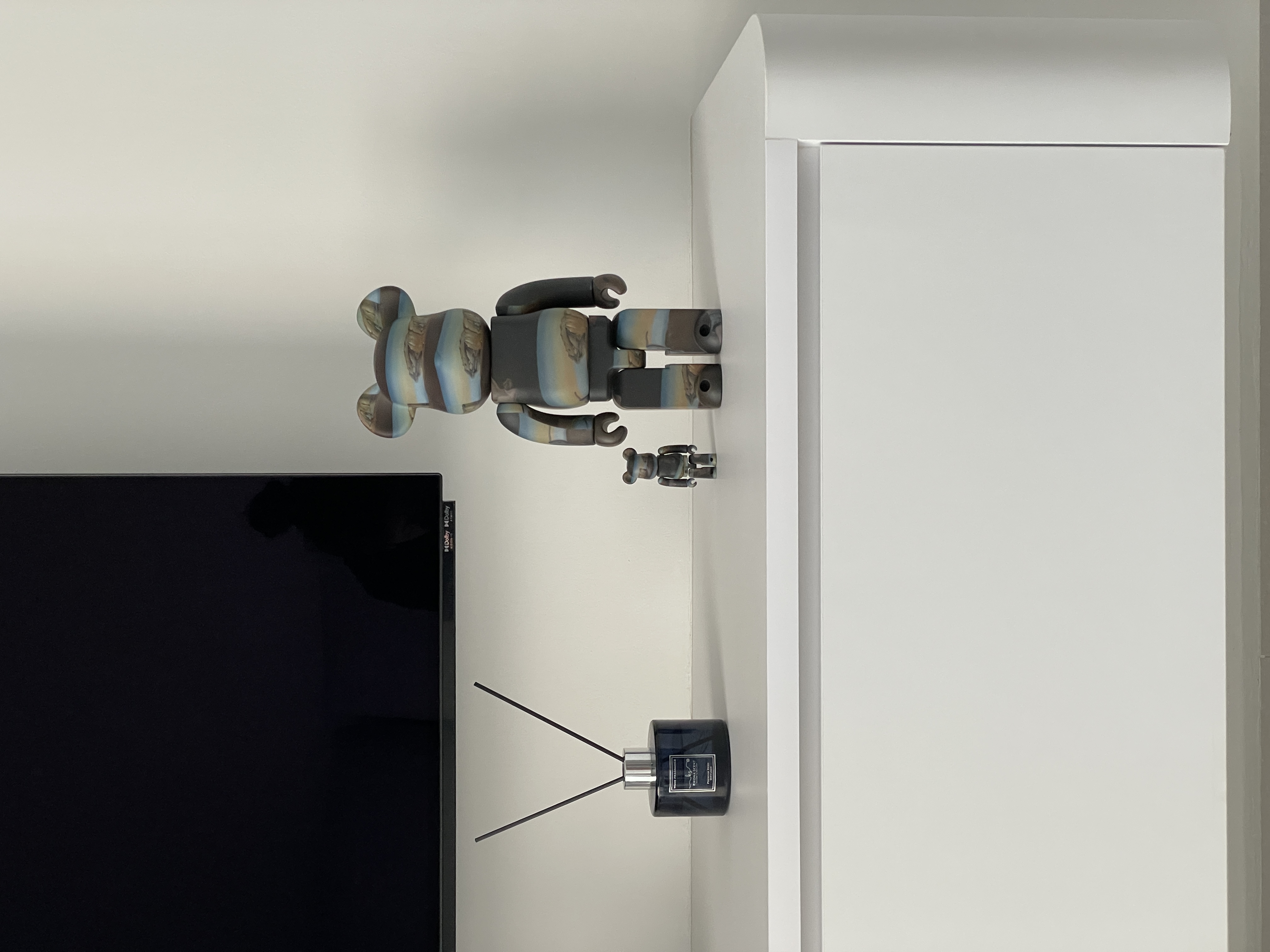 A Minimalist White & Grey Living Room: Heart Of Our Home ✨ - Cartoon-style robot figure on white wall, Black TV screen beside