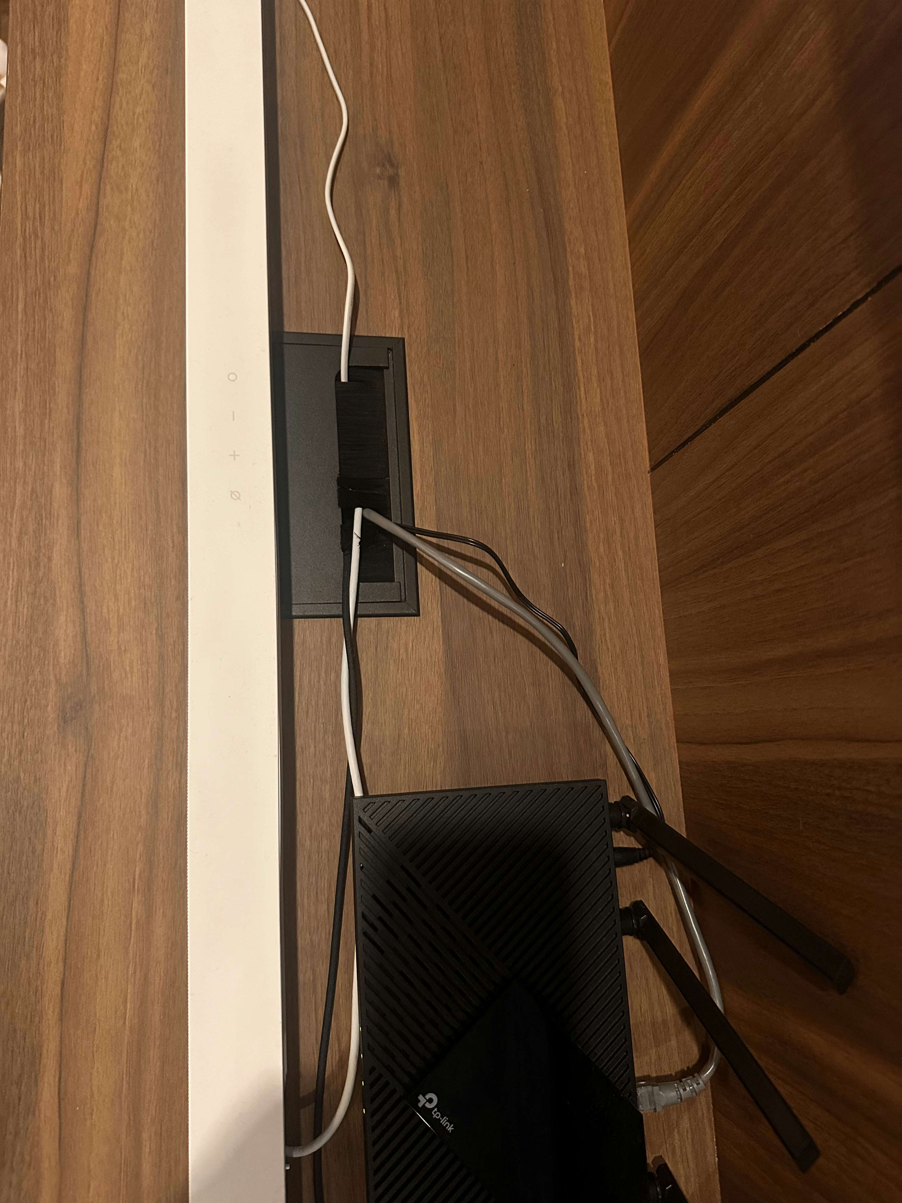 Lounging Area with a Warm Glow✨ - Wooden surface, black power strip, white cable, black router, black device, black casing