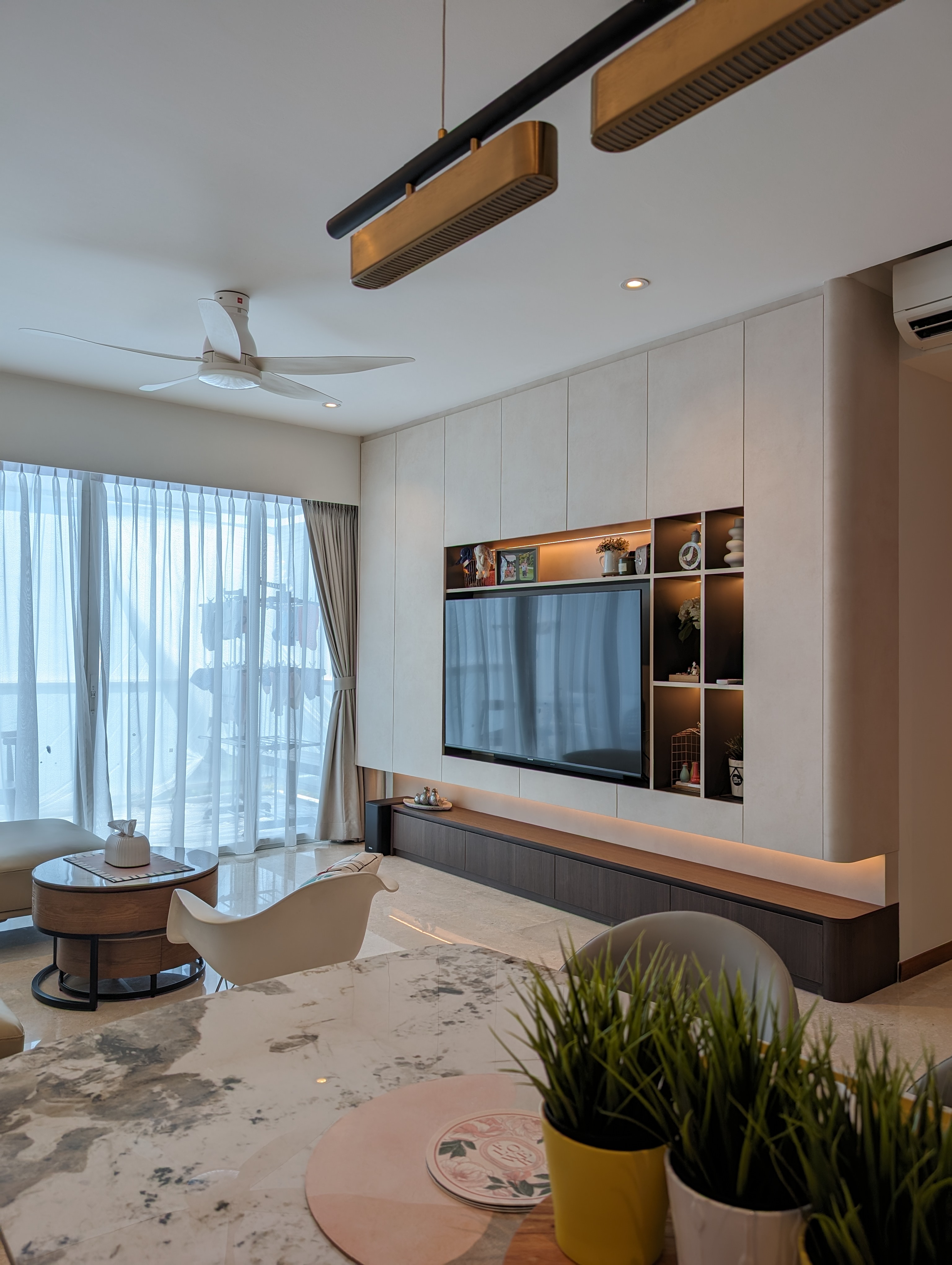 Where is the mess? We hid it! - Modern living room with large flat-screen TV, minimalist furniture, sleek ceiling fan, soft