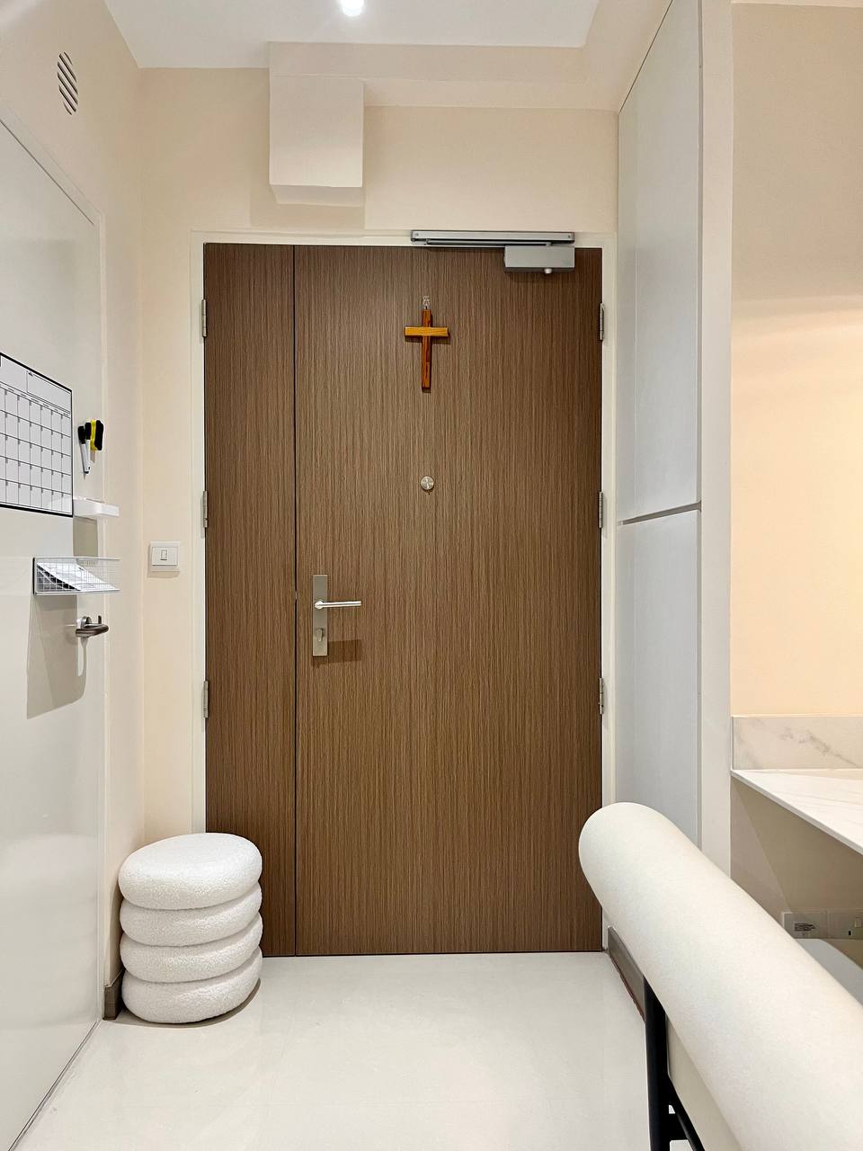 Turning a Small Entryway Into a Functional Space Without Built-ins - Wooden door, cross decoration, white ceramic stool