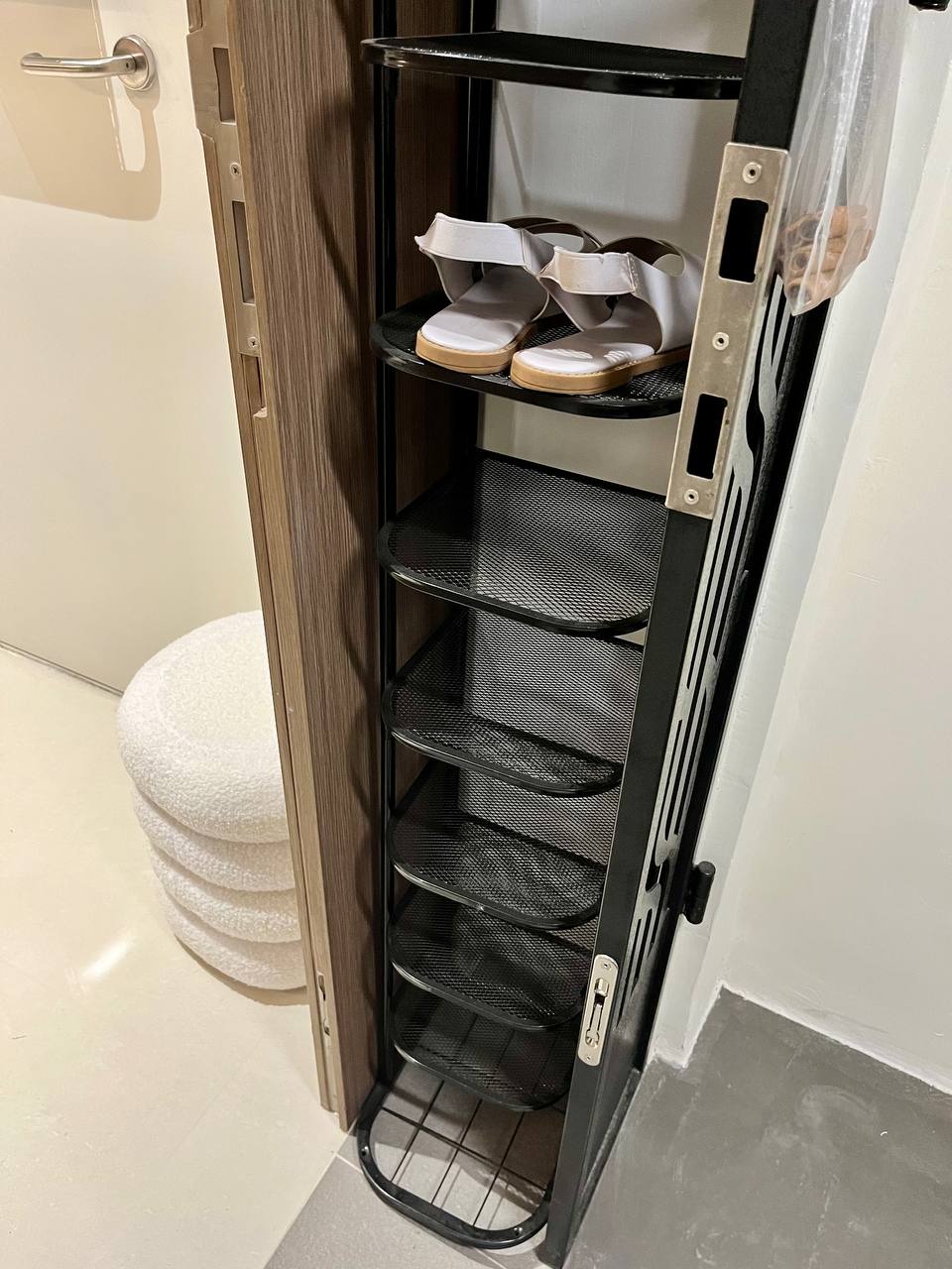 Turning a Small Entryway Into a Functional Space Without Built-ins - Shelf with shoes, black metal rack, open door, bathroom