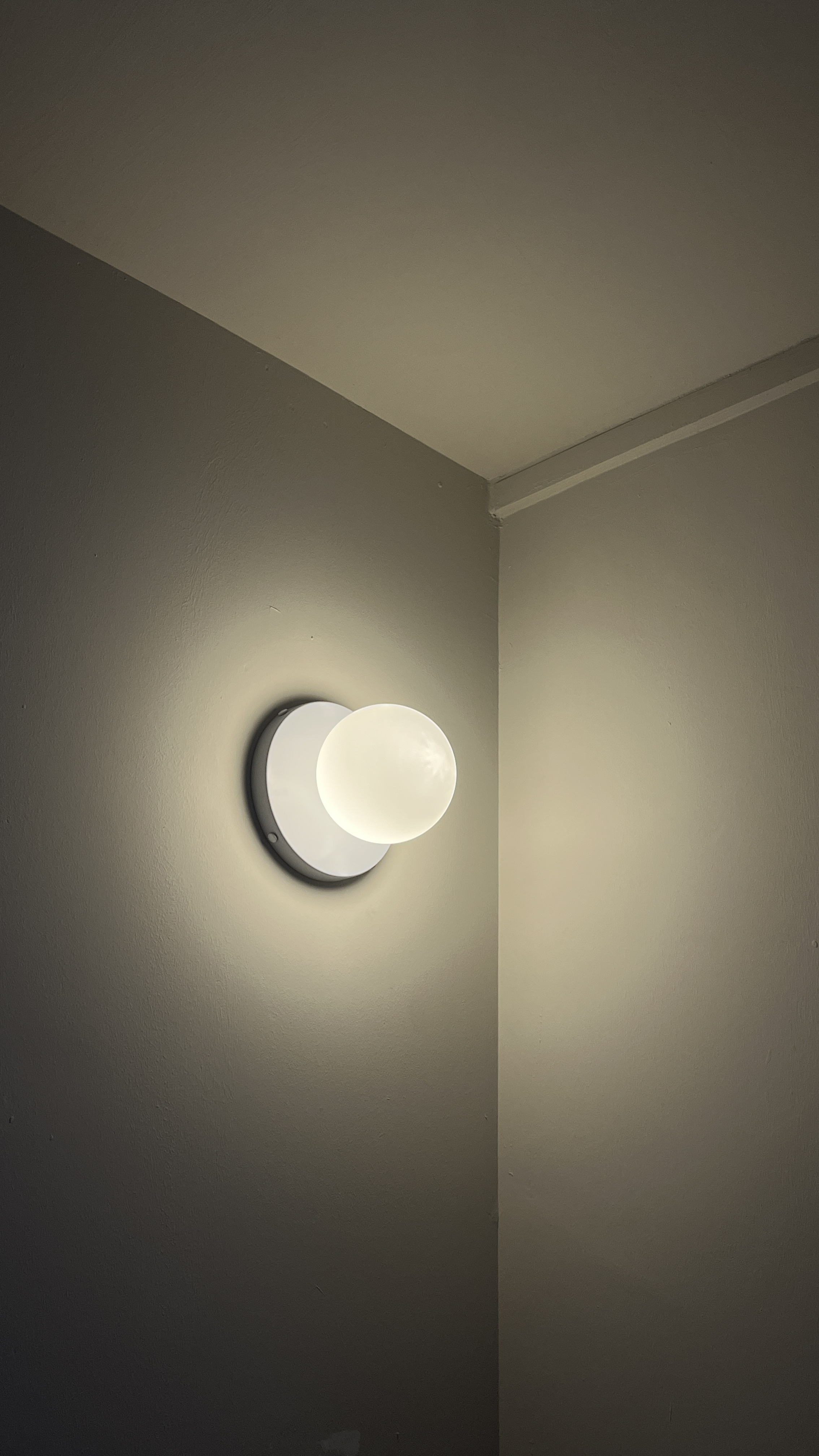 Lighting Tips: Creating Warmth and Style with Lighting - Round wall-mounted light fixture, soft glow, minimalist design