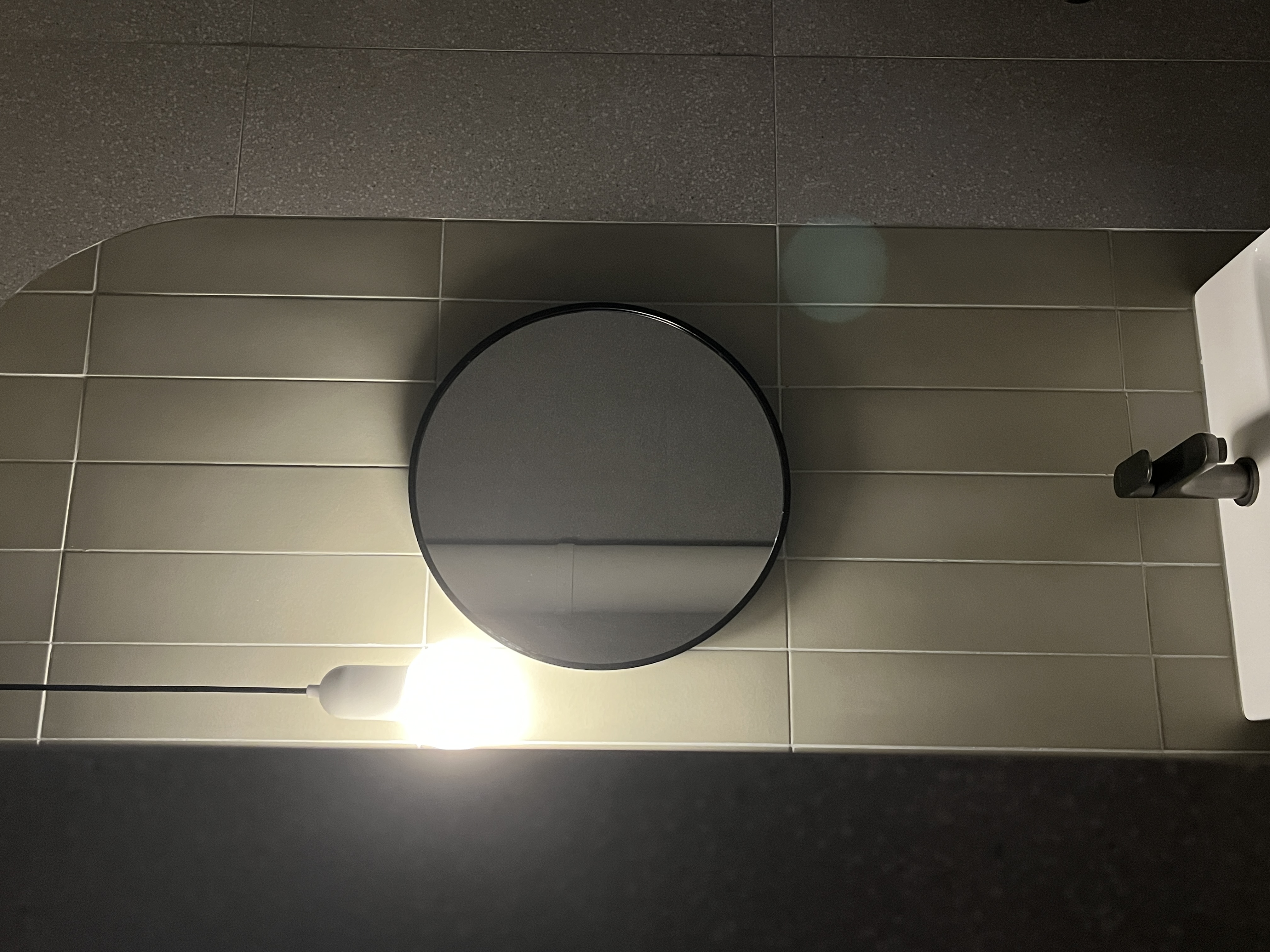 Lighting Tips: Creating Warmth and Style with Lighting - Modern bathroom, circular mirror, minimalist design, tiled wall