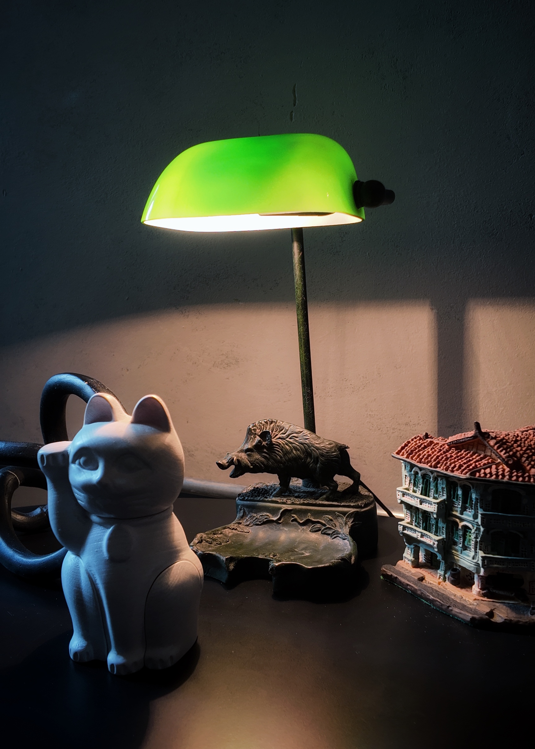 Living within the past and modern - Green desk lamp, white cat figurine, black pig statue, intricately detailed model of a