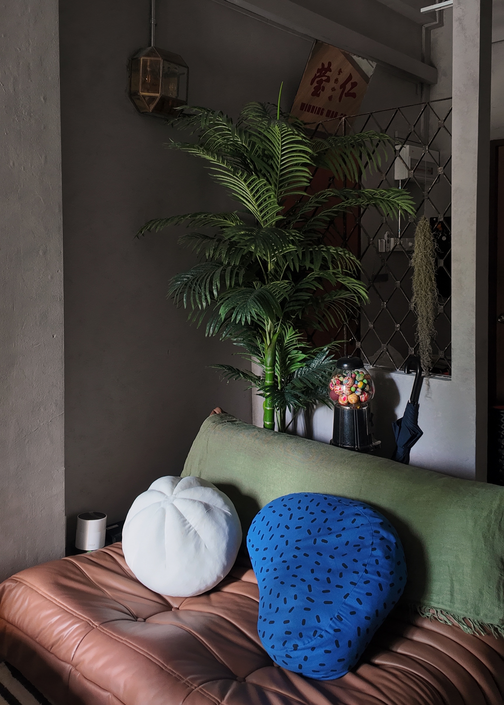 Living within the past and modern - Leather couch, green cushions, white and blue pillows, indoor plant, hanging lantern