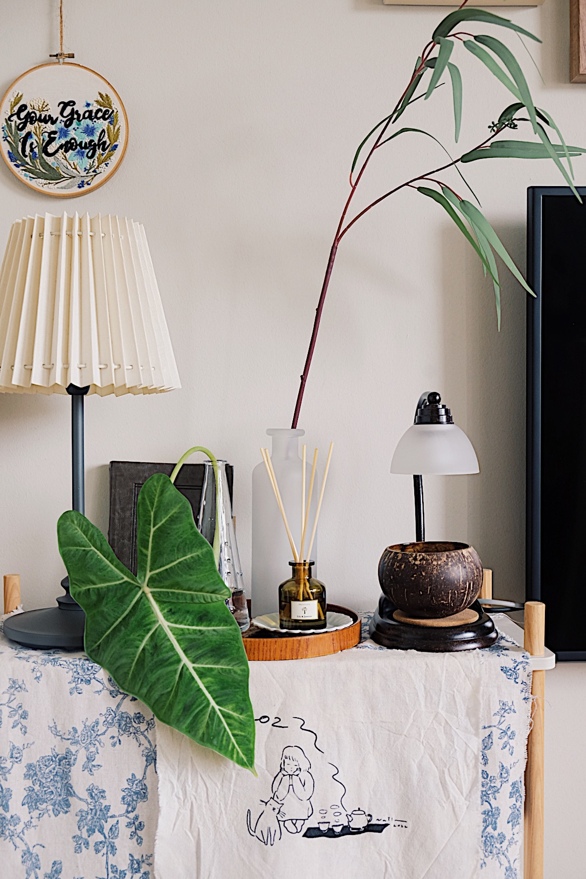 Styling gallery walls filled with memories in our Living Room (+TIPS) - vibrant green plant, elegant lamp, white tablecloth
