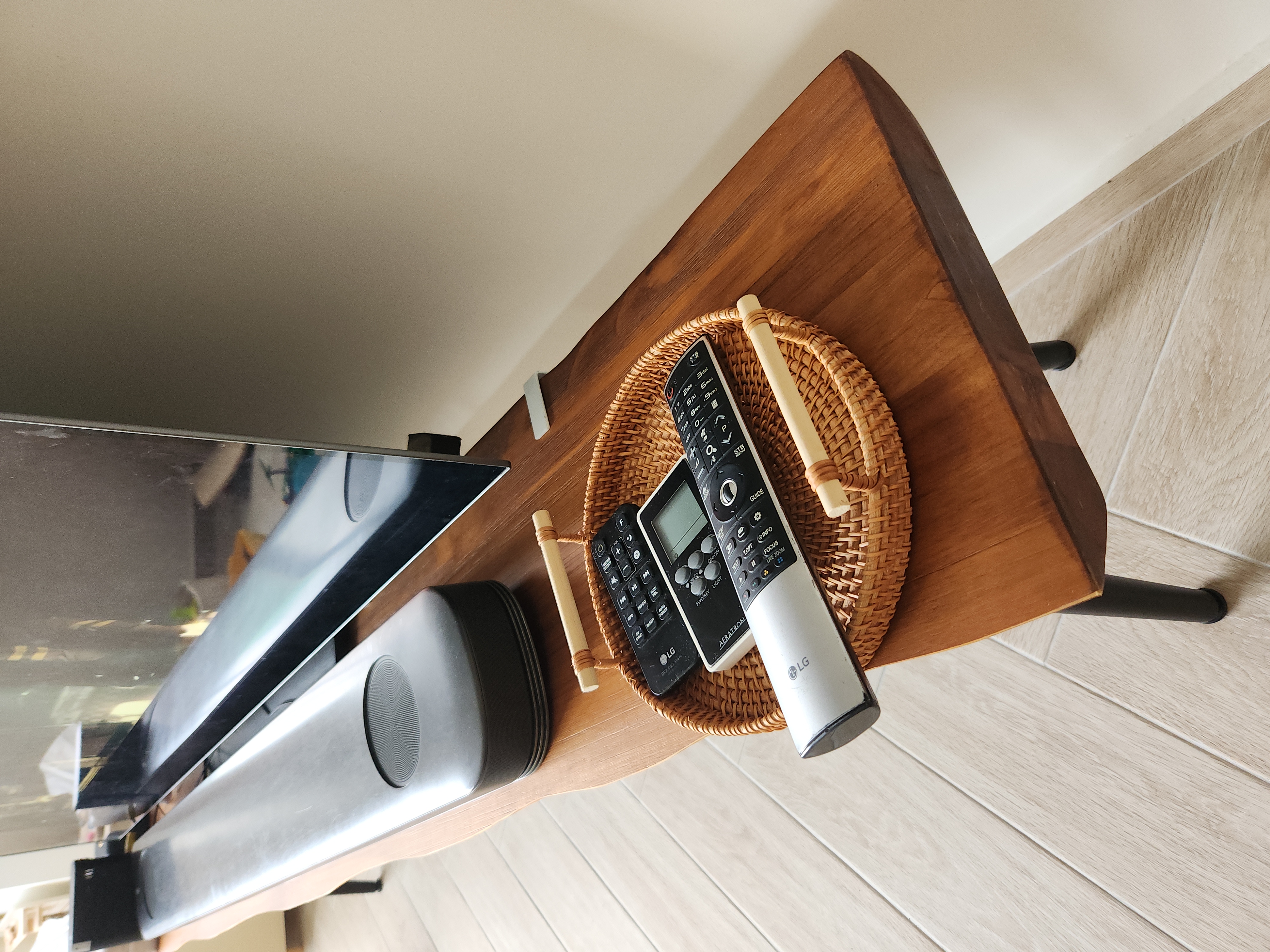 Hacked away wall for our Living room - Wooden table, modern design, TV stand, remote controls, LG brand, black and silver