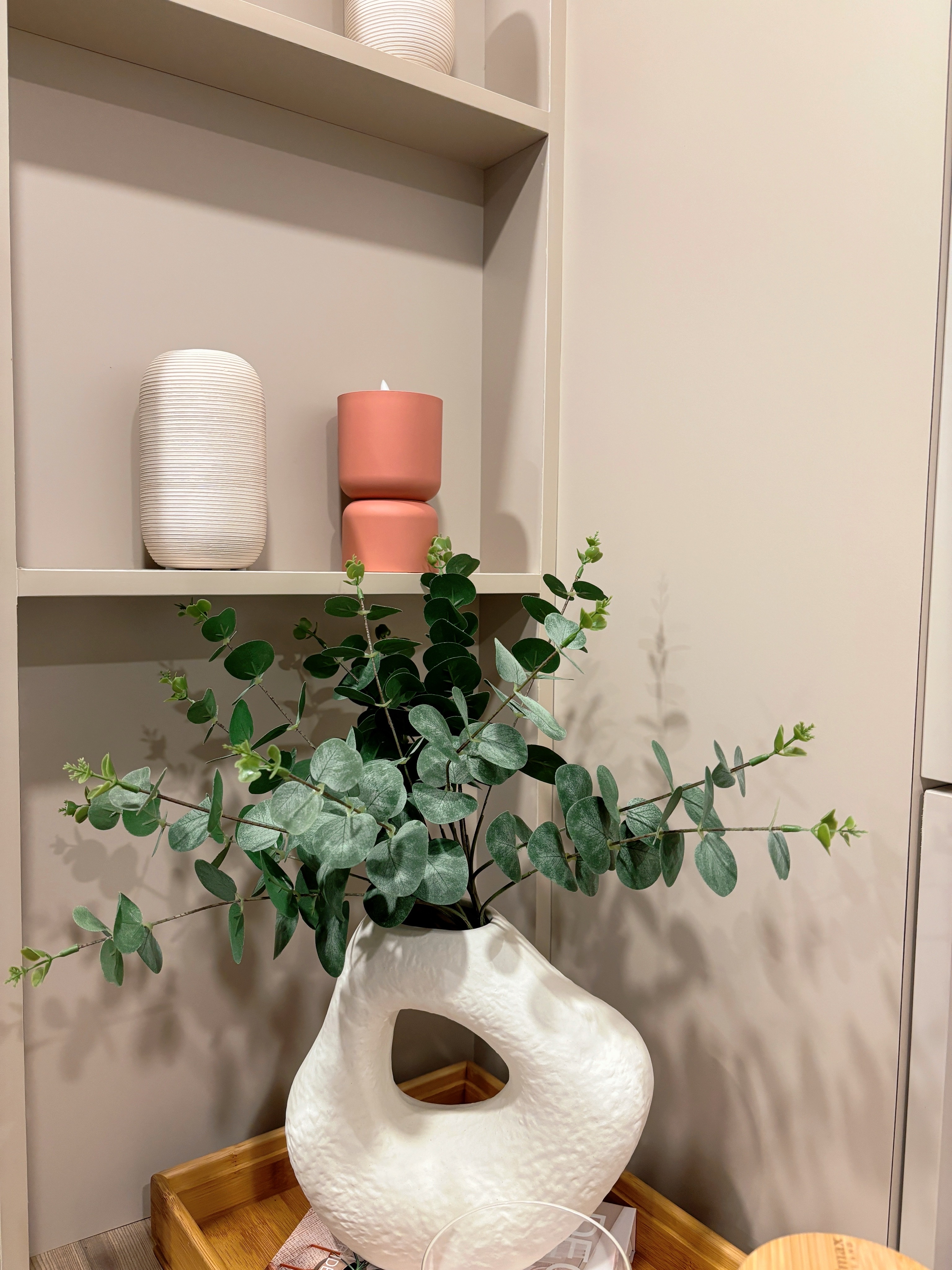 Sprucing Up Home Decor: Adding Greens for a Fresh Touch - White textured vase, green leafy plant, indoor setting, minimalist