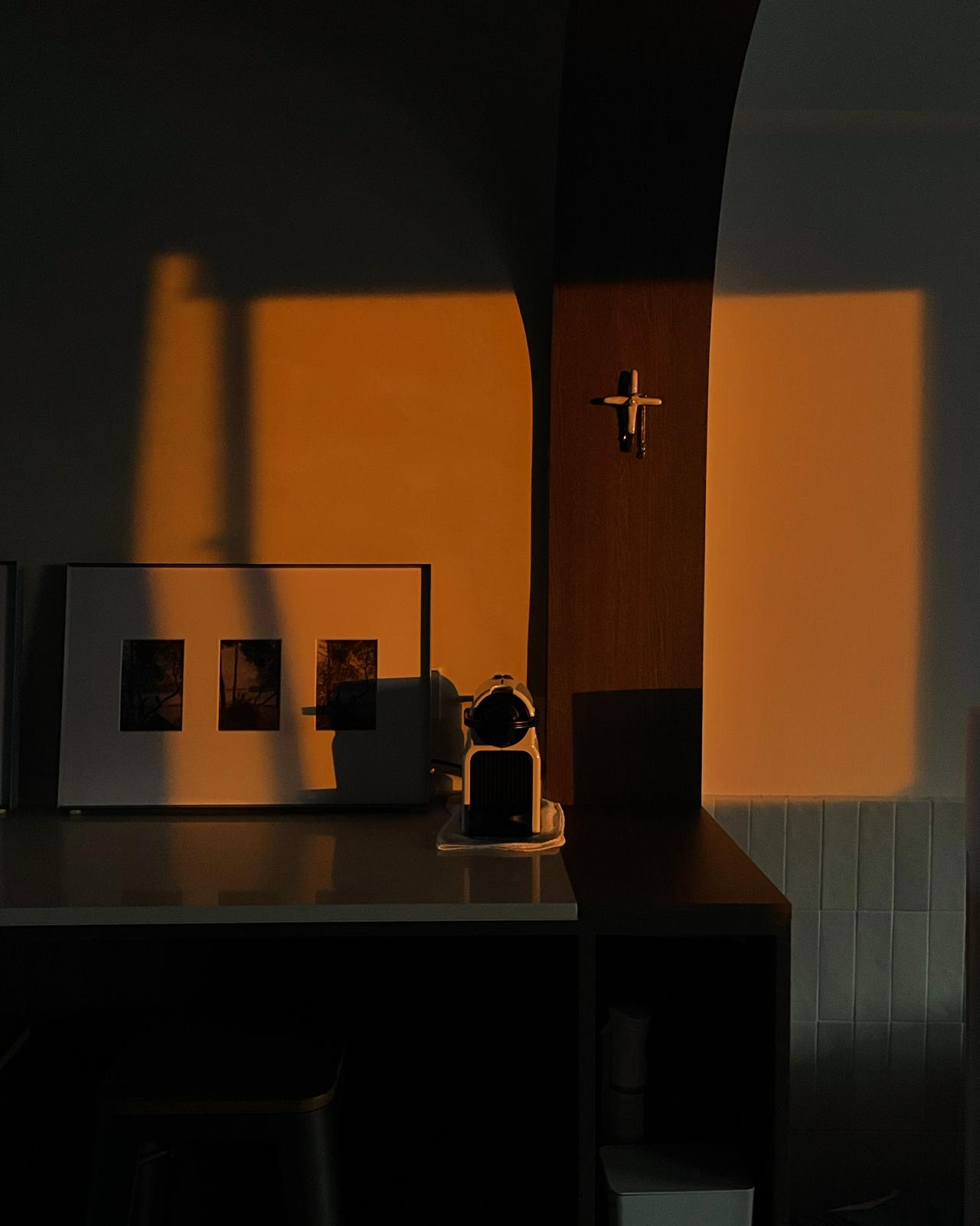 The Body: Ultimate Cosy Living Room with a Half Feature Wall?! - Sunset over desk, warm orange glow, silhouette of shadow