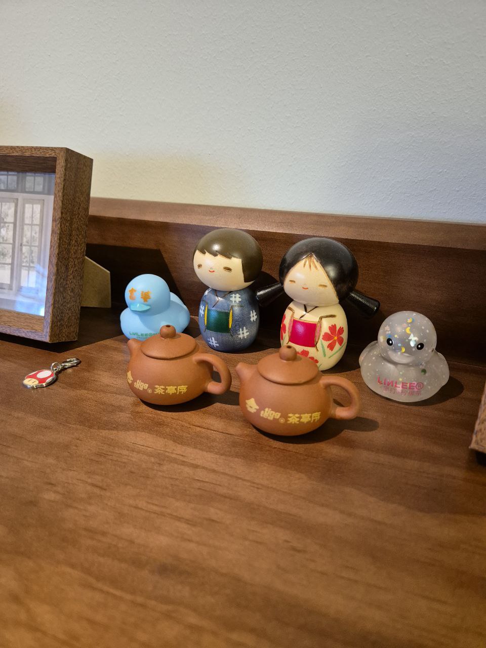 Sunset hues along our Entryway... a space for us to keep growing into - Tea set, figurines, traditional attire, blue duck