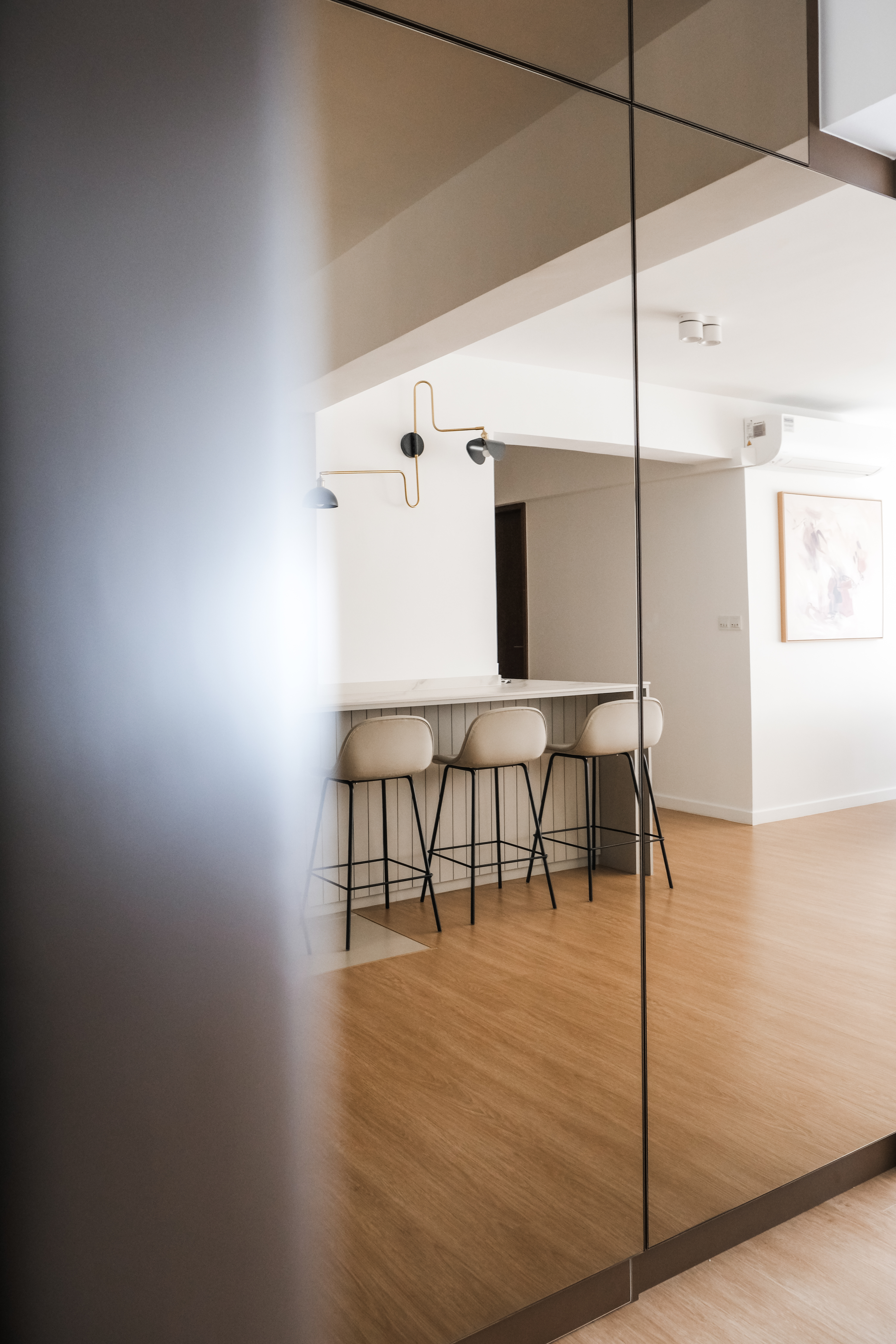 Inviting Entryway to a Spacious Open-Concept Home - Modern minimalist kitchen, sleek bar stools, wooden floor, contemporary