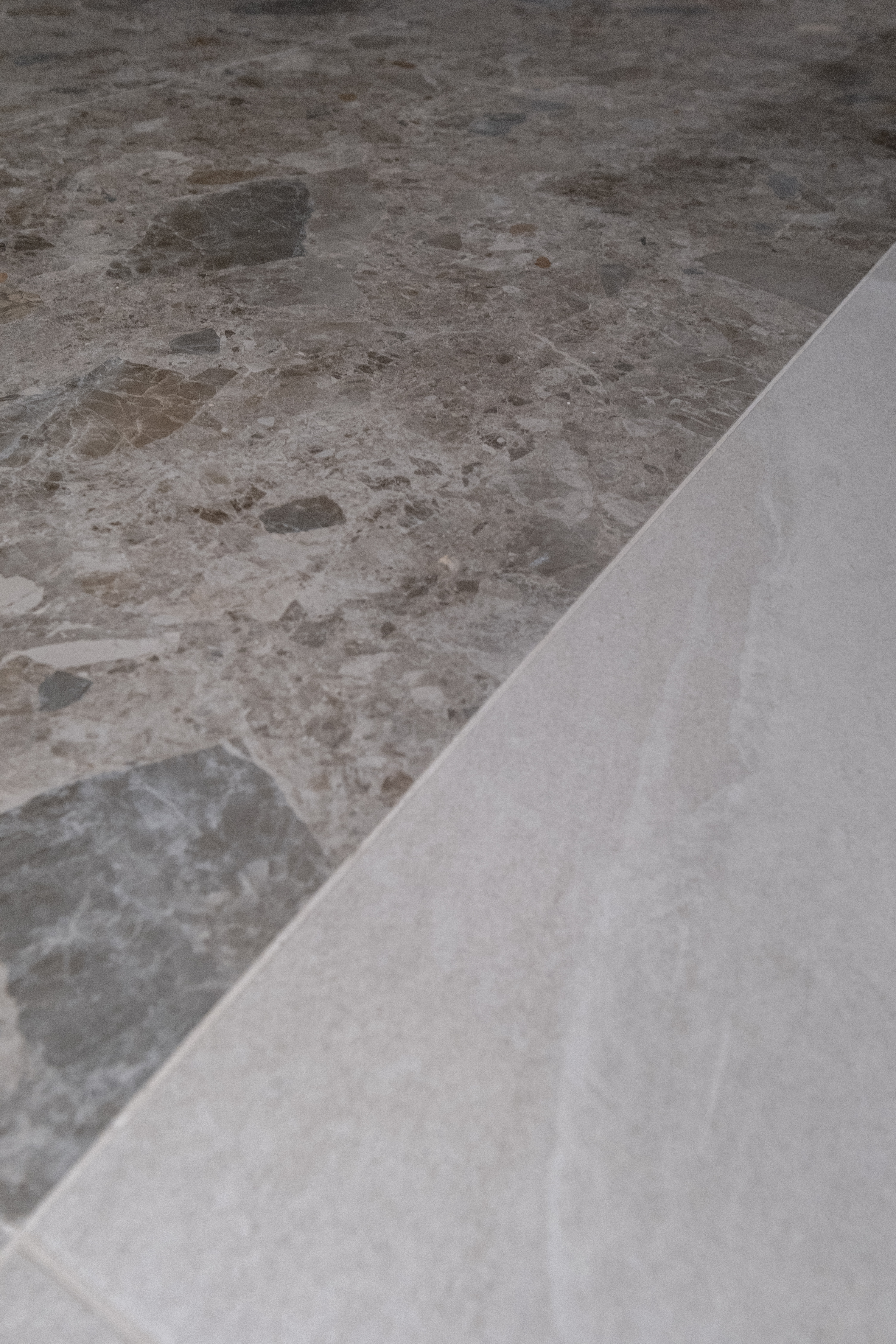 Entryway: Blending Retro Glass Bricks with Modern Contemporary Design - Marble floor with a mix of gray and beige stones