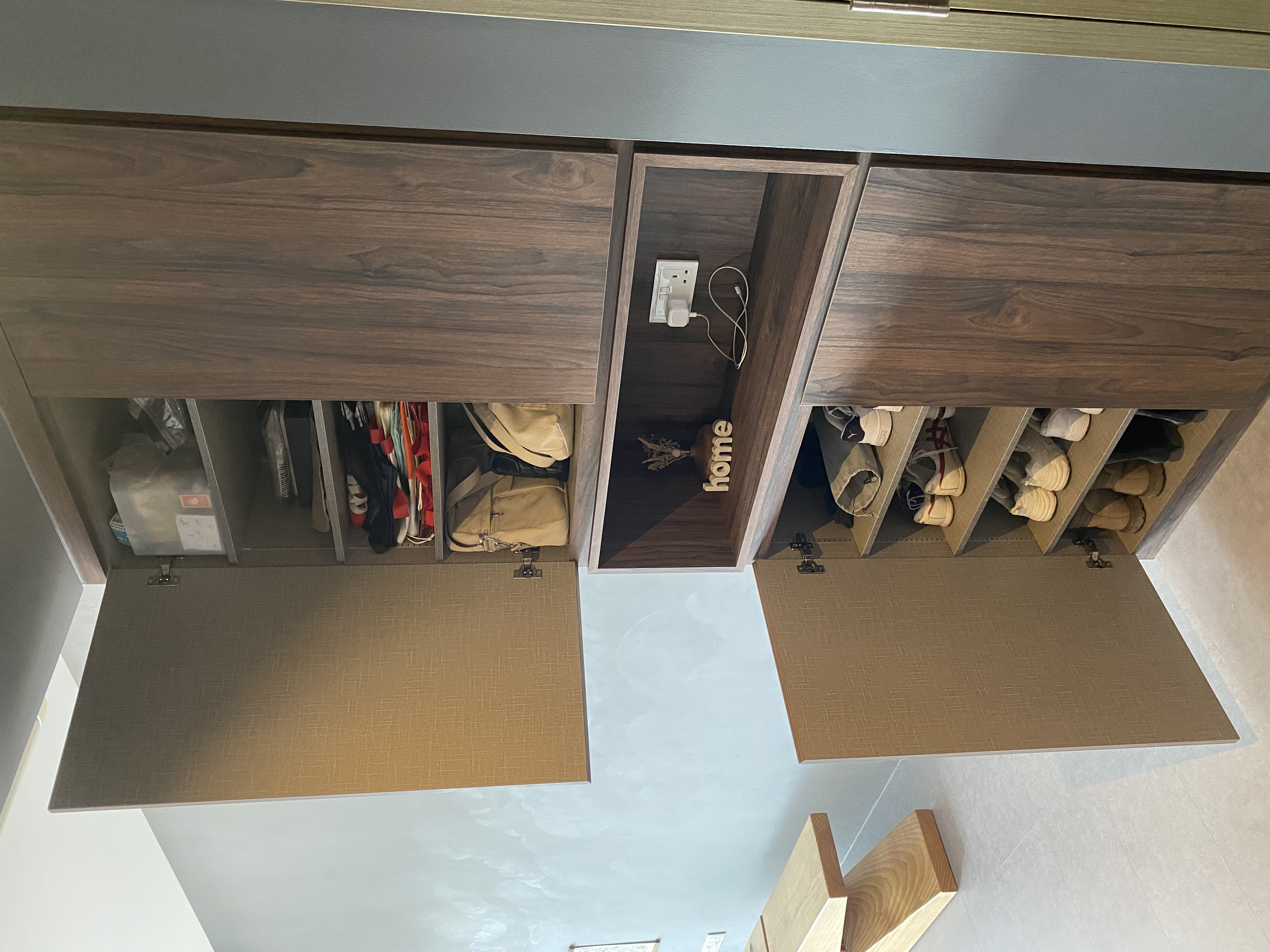 Gallery style entryway with dark wood fluted panel - Wooden wardrobe with neatly organized compartments, beige rug beneath