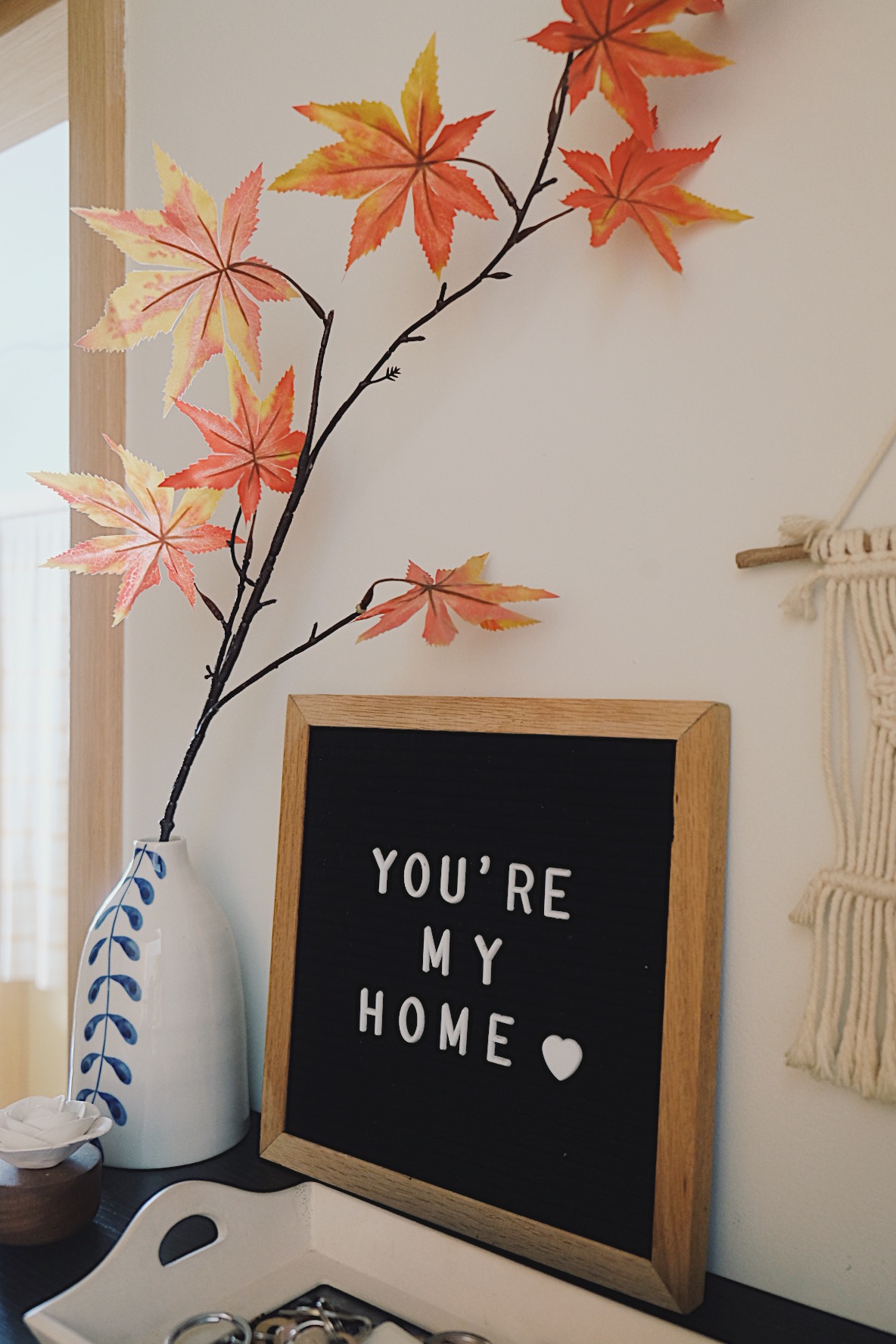 Cube-sized Foyer in a Dual-key Apt with a shoe rack and decor touches - vibrant autumn leaves, handmade paper art, decorative