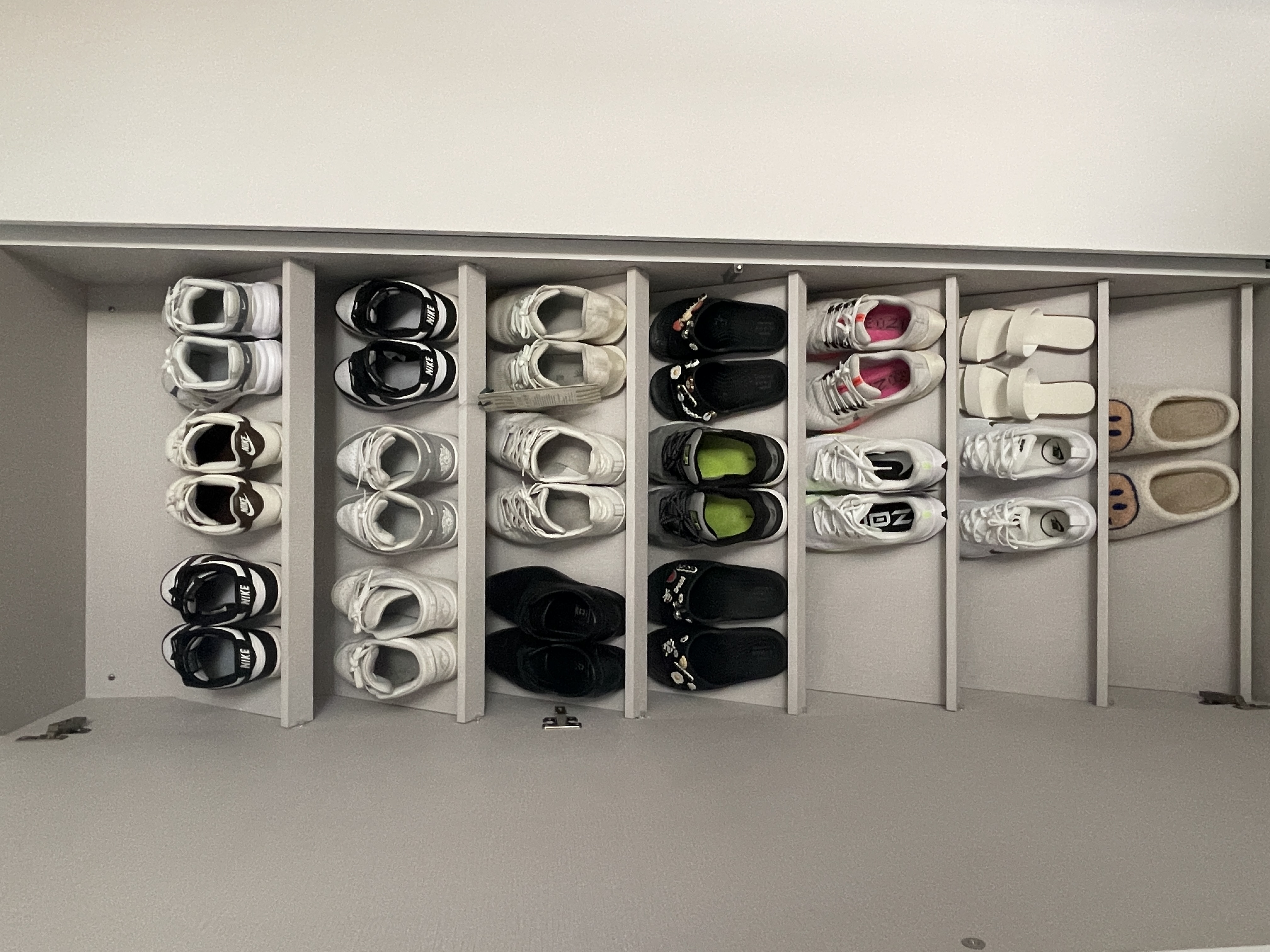 Inviting Entryway: Concealed Bomb Shelter and Shoe Storage - White sneakers, black and white sneakers, black slides, white
