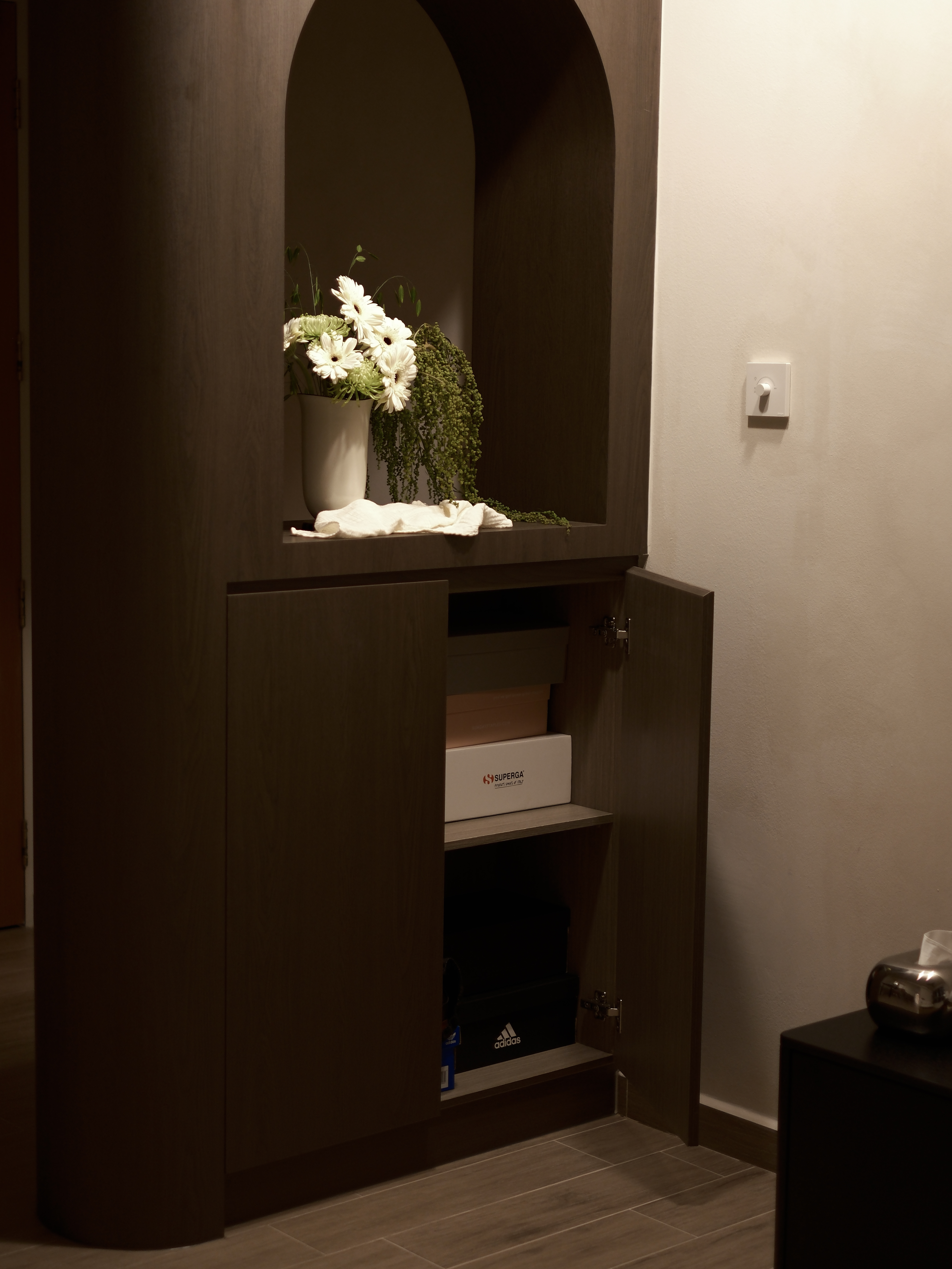 Entryway: Curves and Arches in Our Full-Height Partition - vase with white flowers, green vines, wooden cabinet, soft