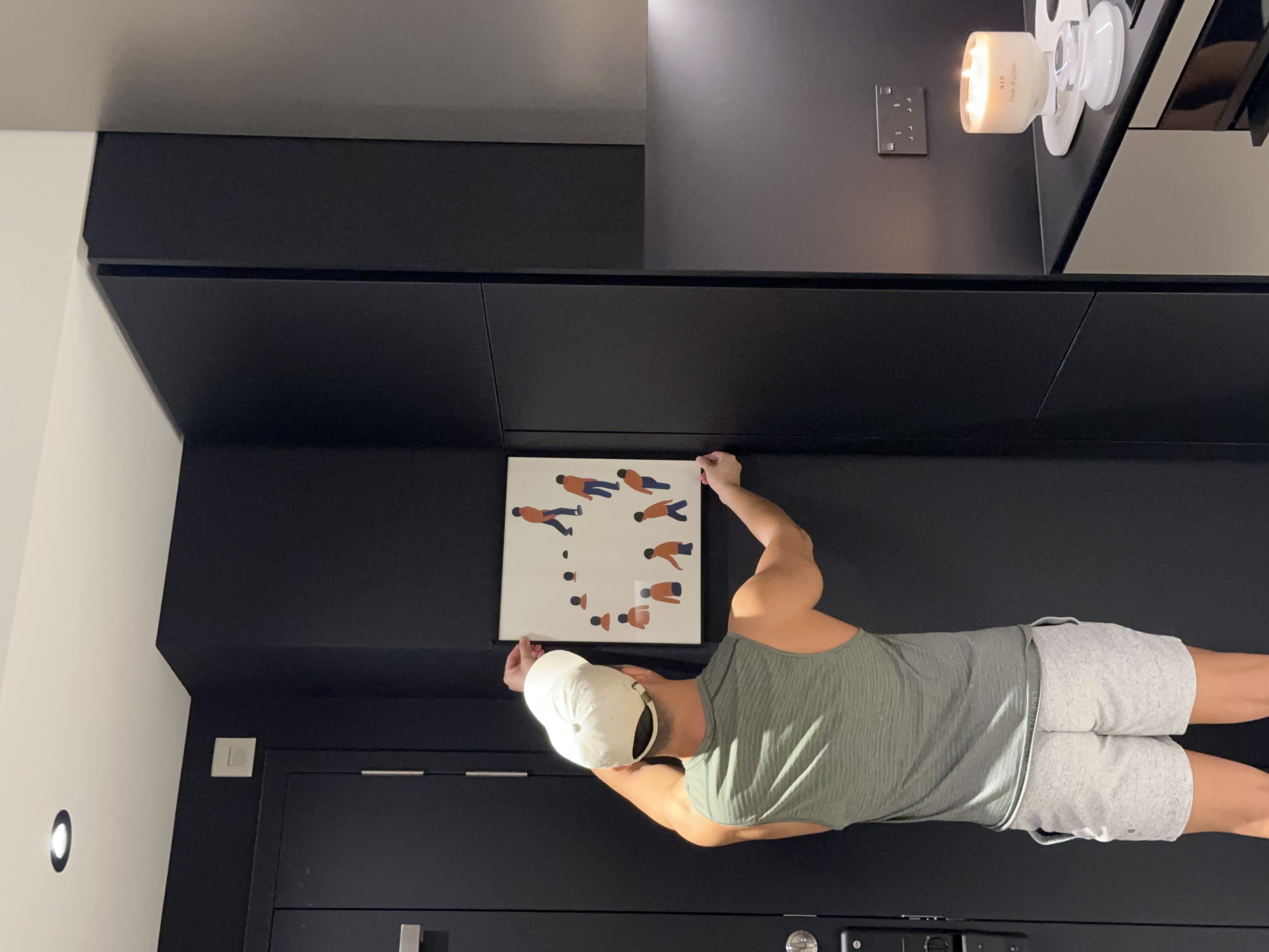 A Seamless Welcome: Introducing Our Stylish Entryway - Modern minimalist interior, sleek black cabinets, person standing