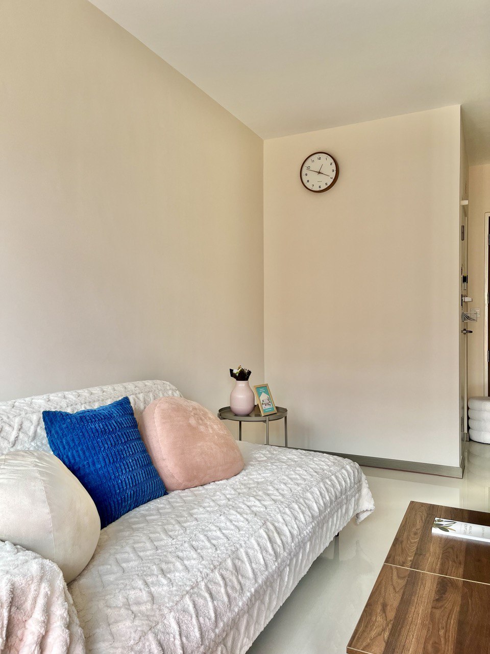 Living Room: Ritz Carlton Inspired Space With Settee in a 3-Room BTO - Cream-colored walls, cozy sofa with blue and pink