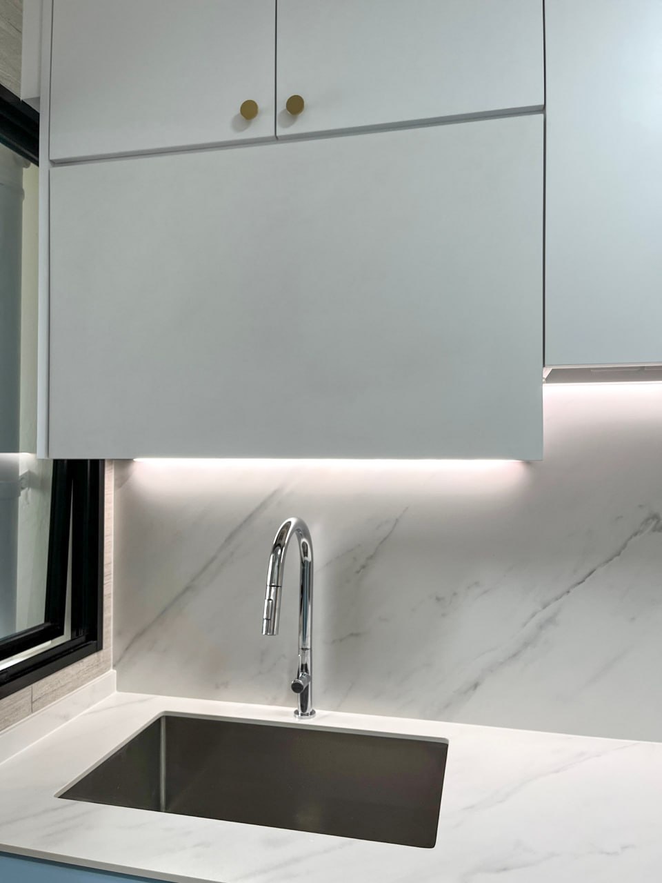 Our Santorini Themed Kitchen - White kitchen cabinets, sleek faucet, modern sink, marble backsplash, minimalist design