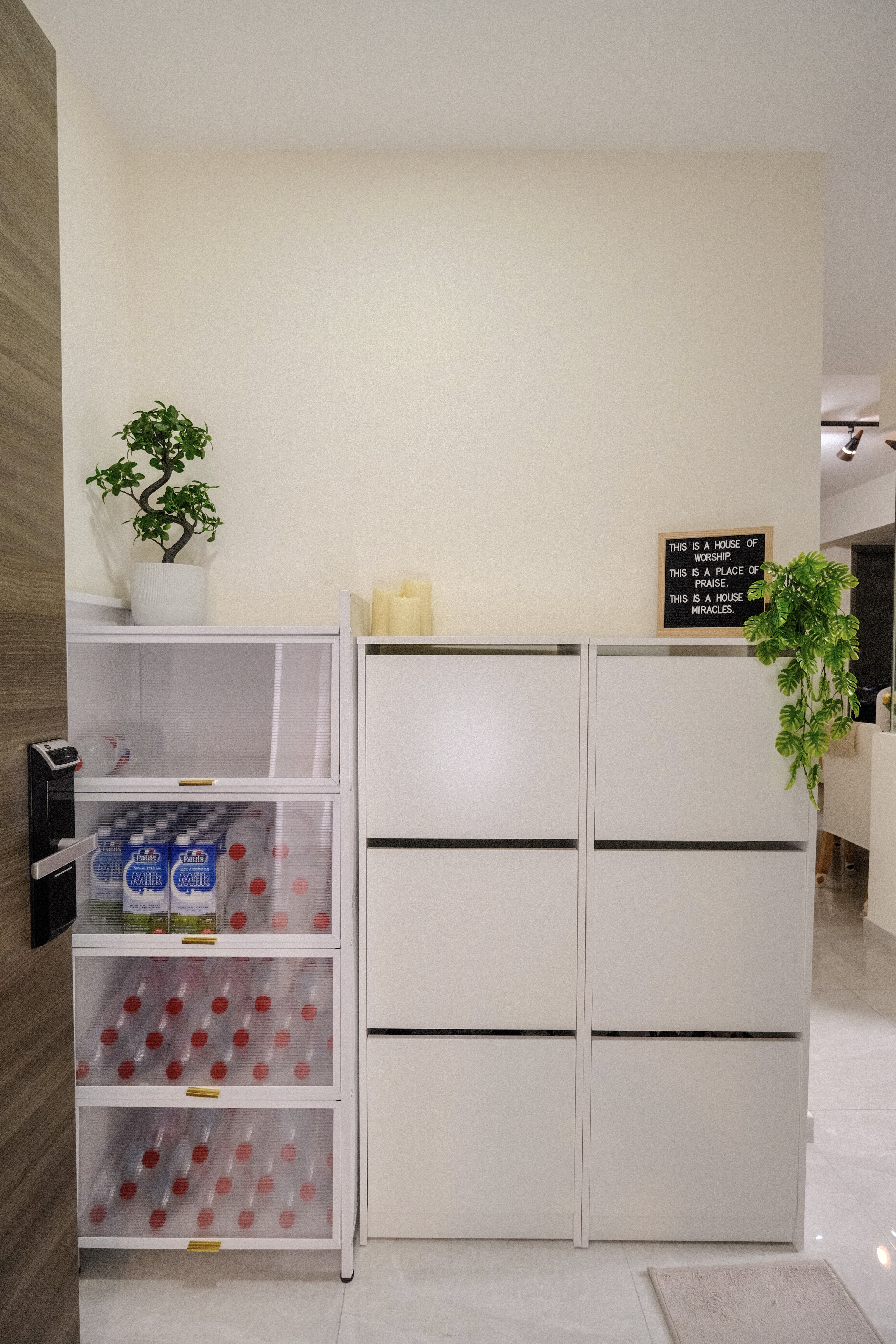 Step into our minimalist entryway!  - Mini fridge with transparent doors, white storage cabinet, potted plant on top