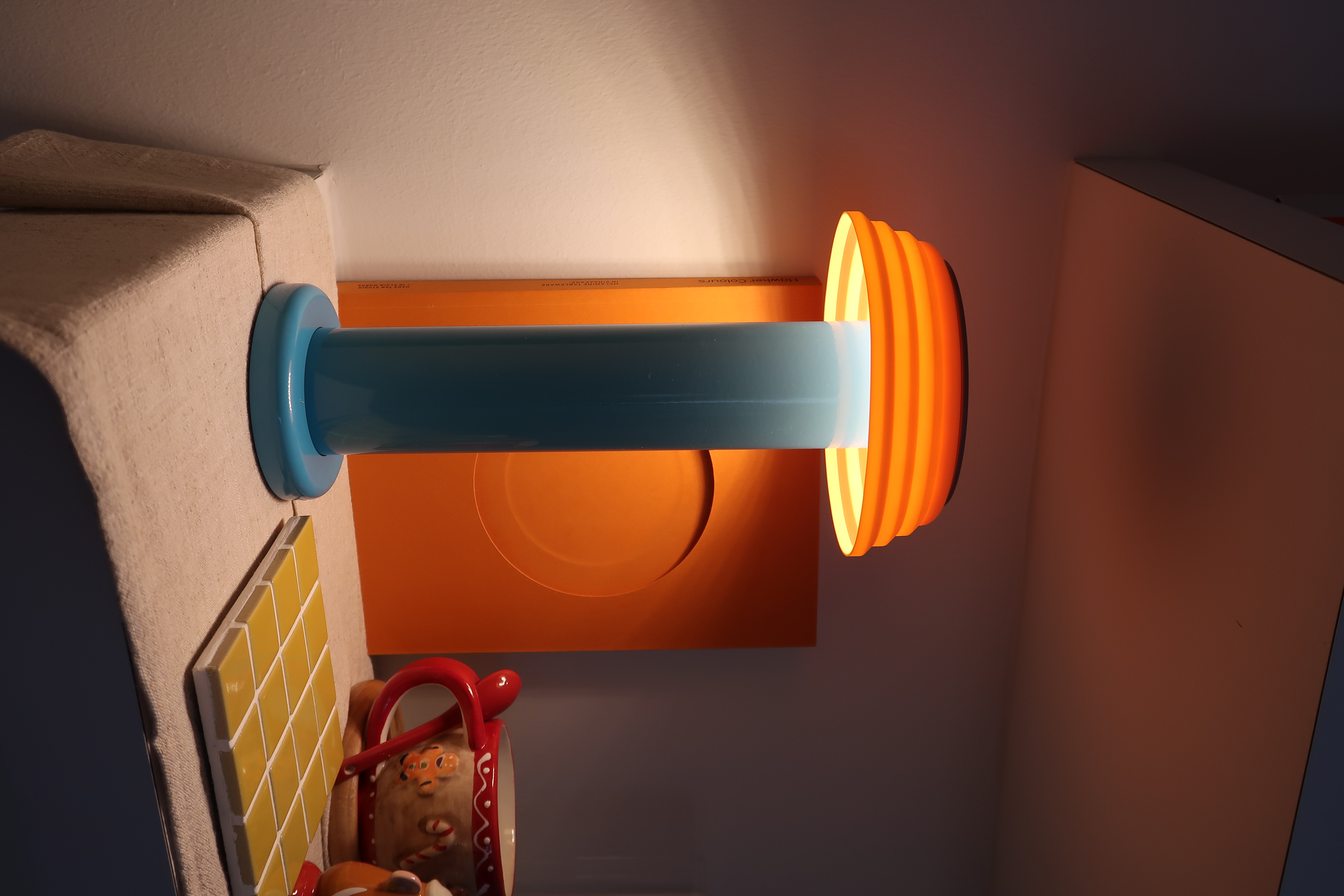 How we create a cosy ambience with accent lighting  - Wall-mounted light fixture, orange wall, soft lighting, orange glow