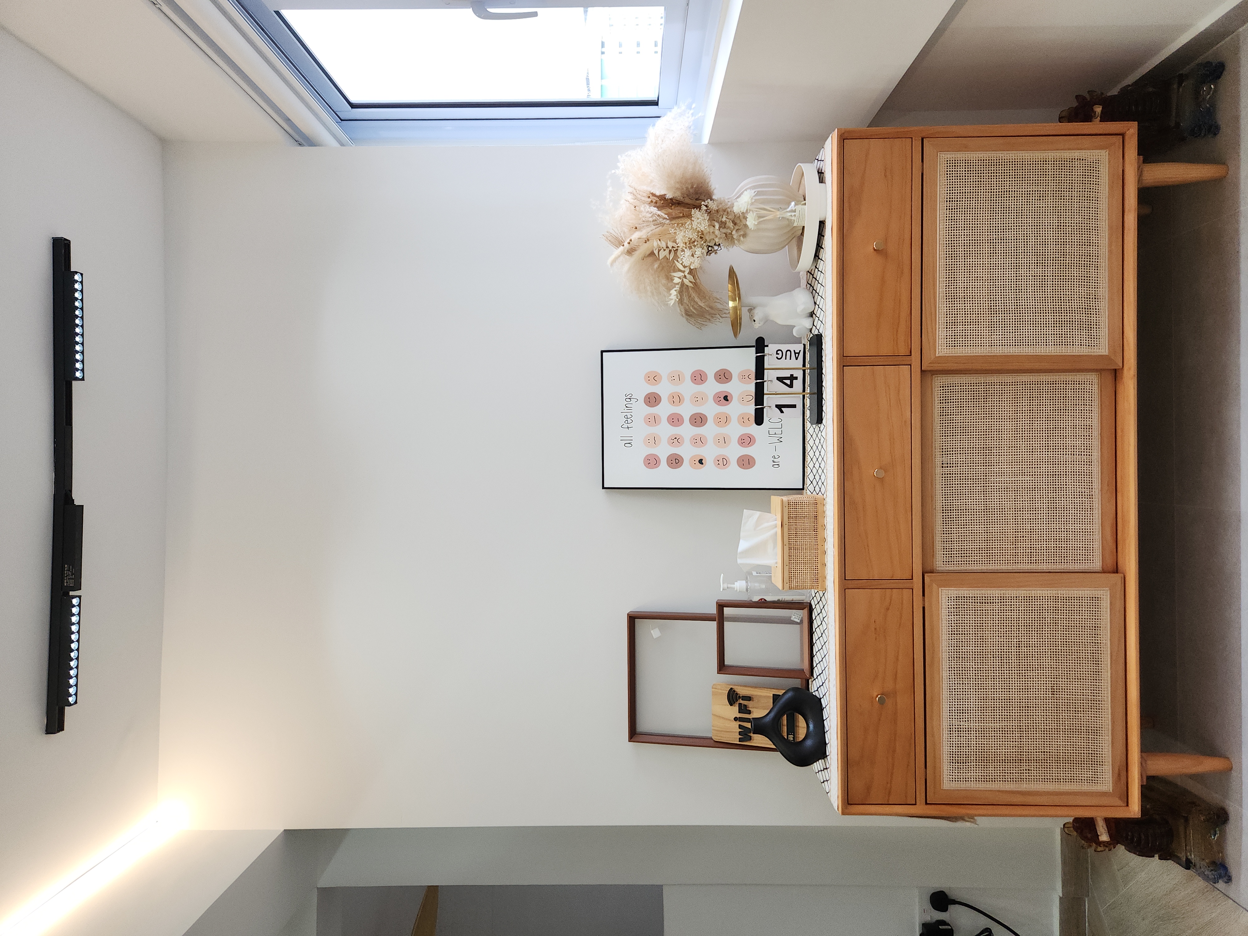 No build-ins for our Entryway - sunlight streaming through skylight, minimalist decor, wooden cabinet, white wall, modern art