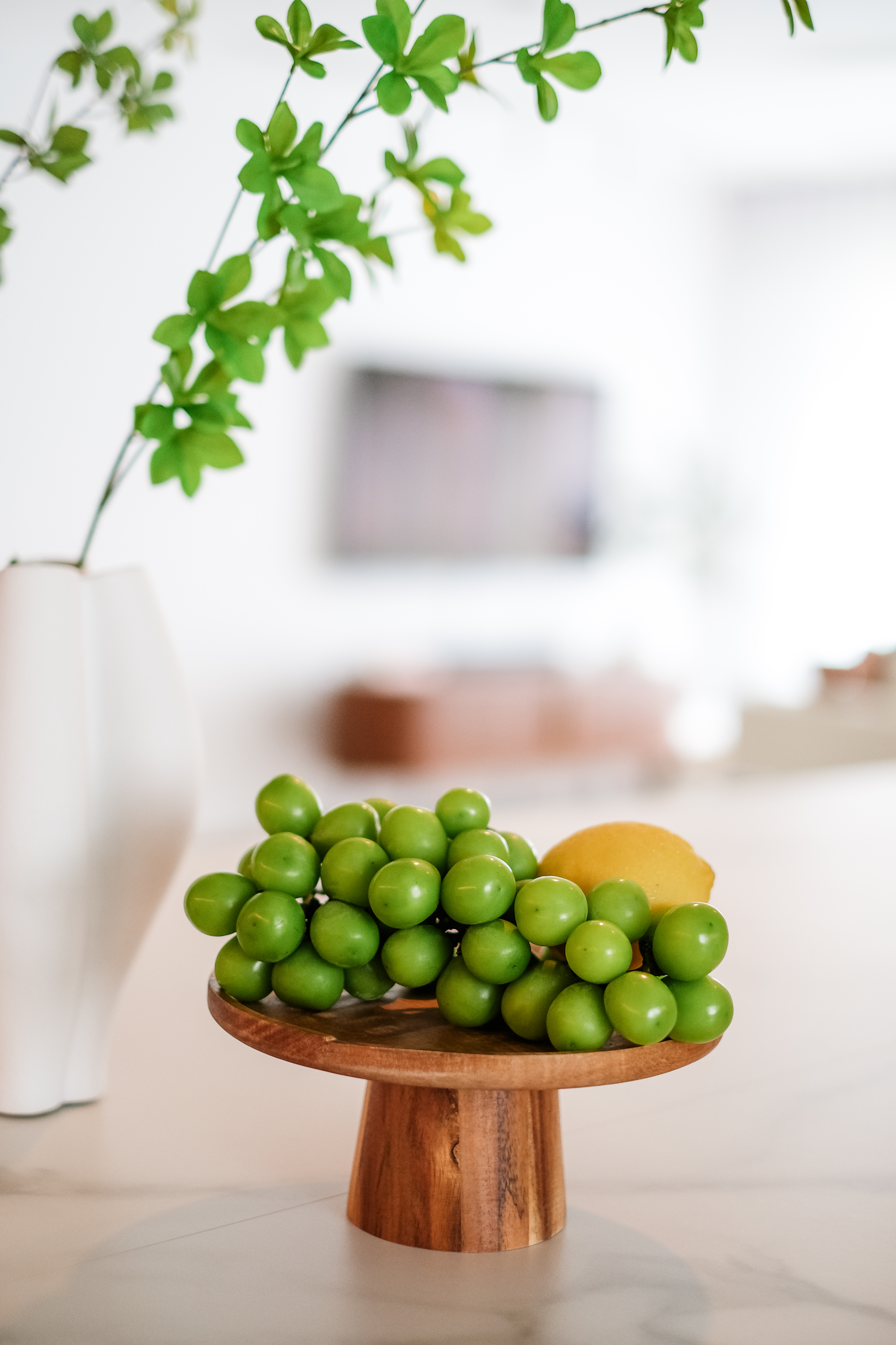 How a Big Pillar Couldn't Stop My Dream of a Large Kitchen Island - Green grapes, yellow lemon, white vase, blurred
