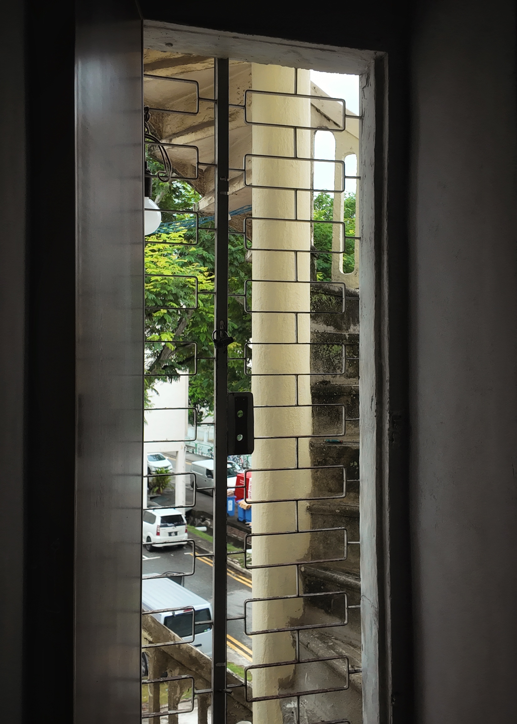 No funny monkey business here! - Window with metal bars and brick-patterned frame, Outdoor view through window with green