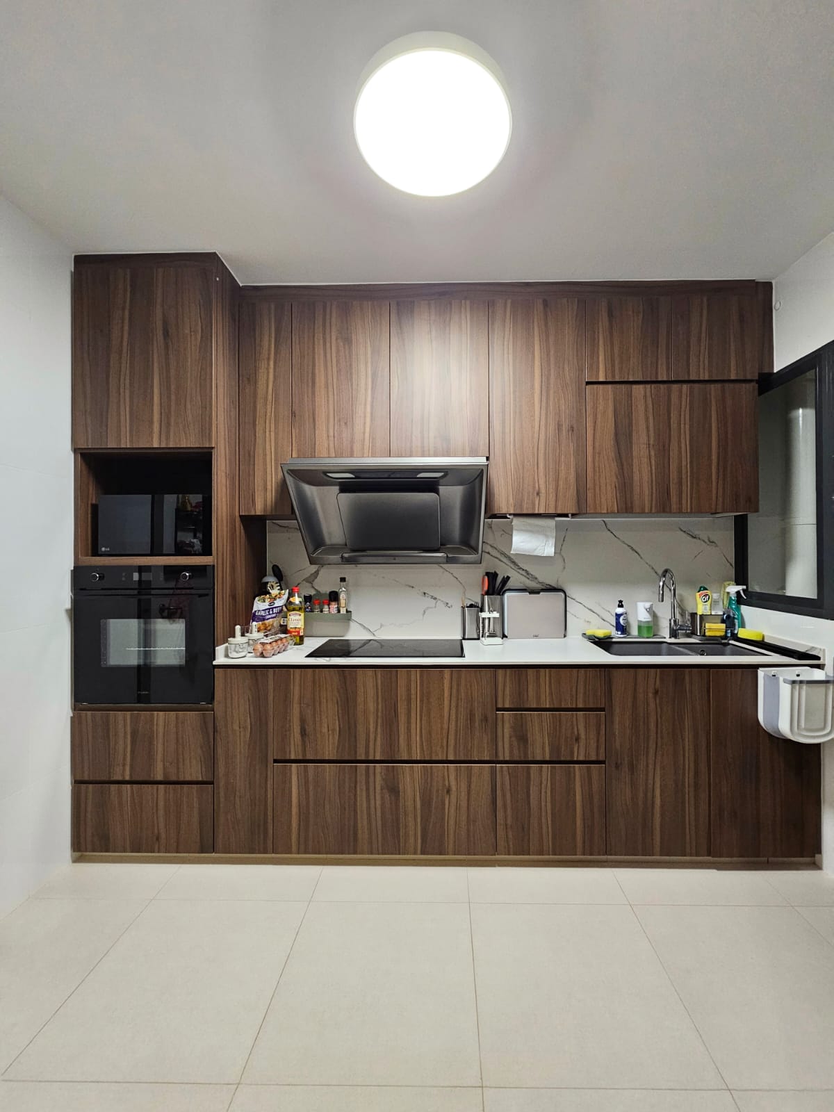 Kitchen: Happiness is homemade food! - Wooden cabinetry, modern kitchen, black oven, stainless steel range hood, marble