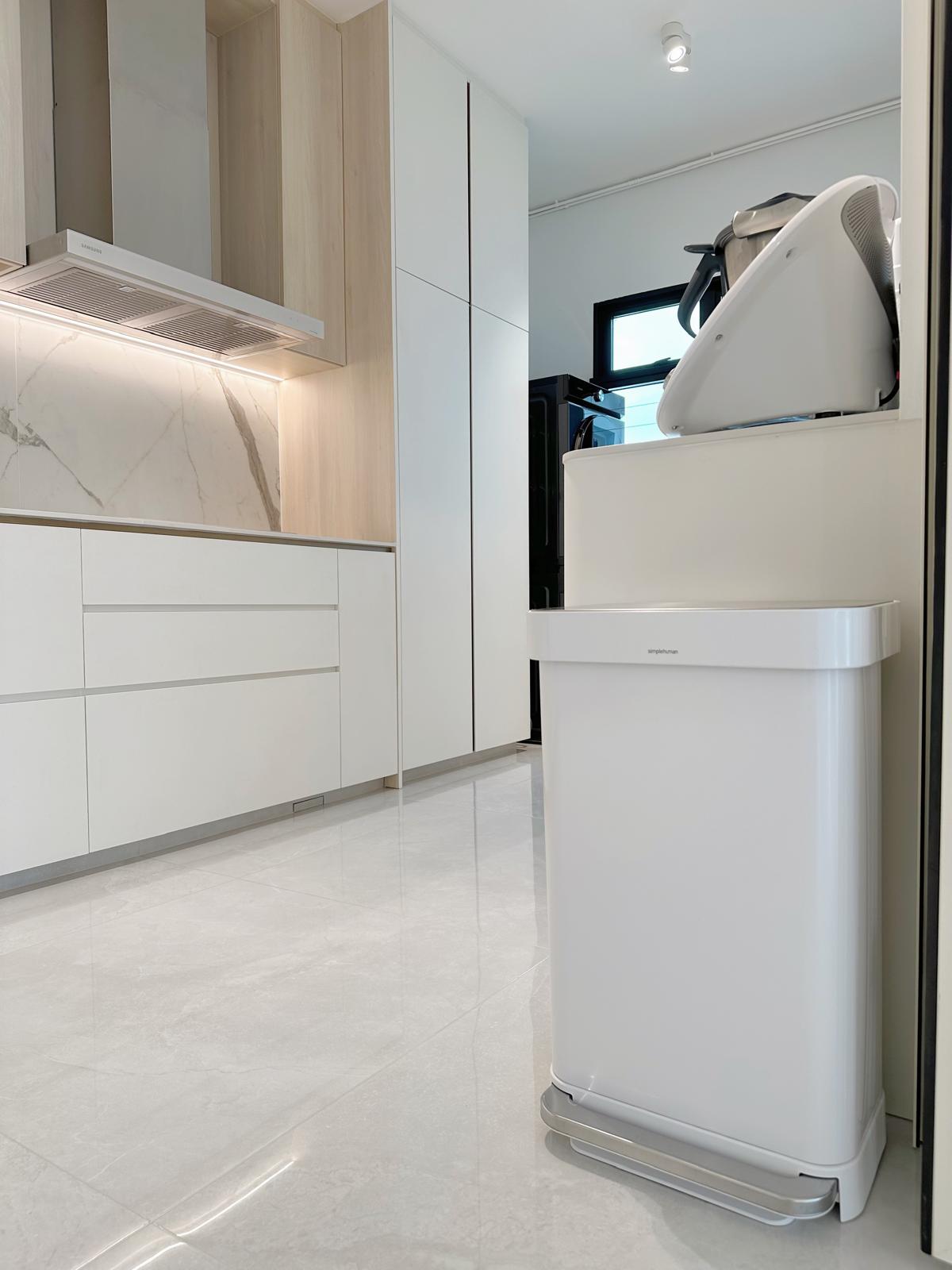 Kitchen: Open (& closed), matching appliances & concealed bomb shelter - White kitchen cabinets, marble backsplash, modern