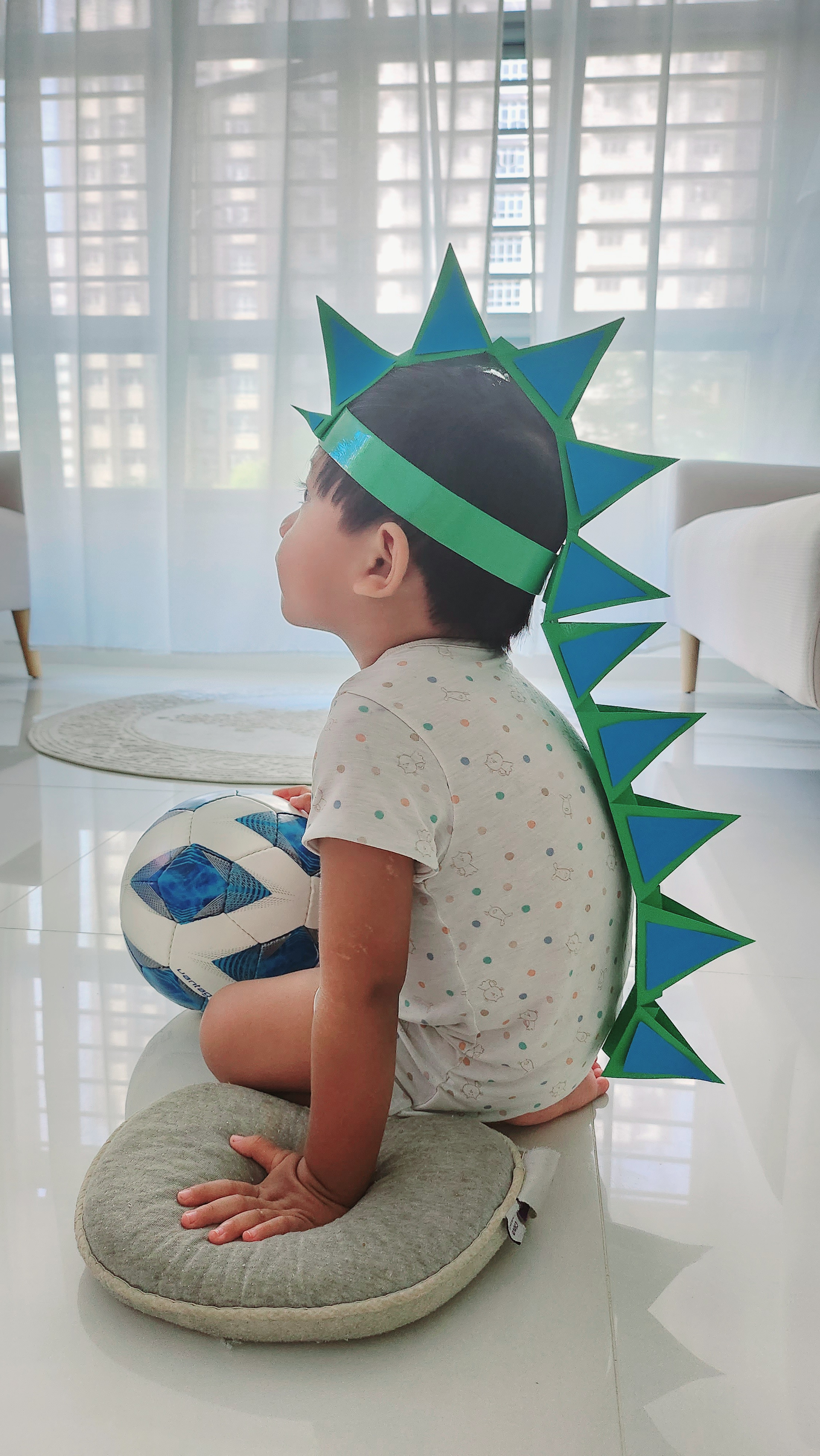 Weekend routine by PunggoHField - Child wearing dinosaur costume, sitting on a cushion, holding a soccer ball, wearing a