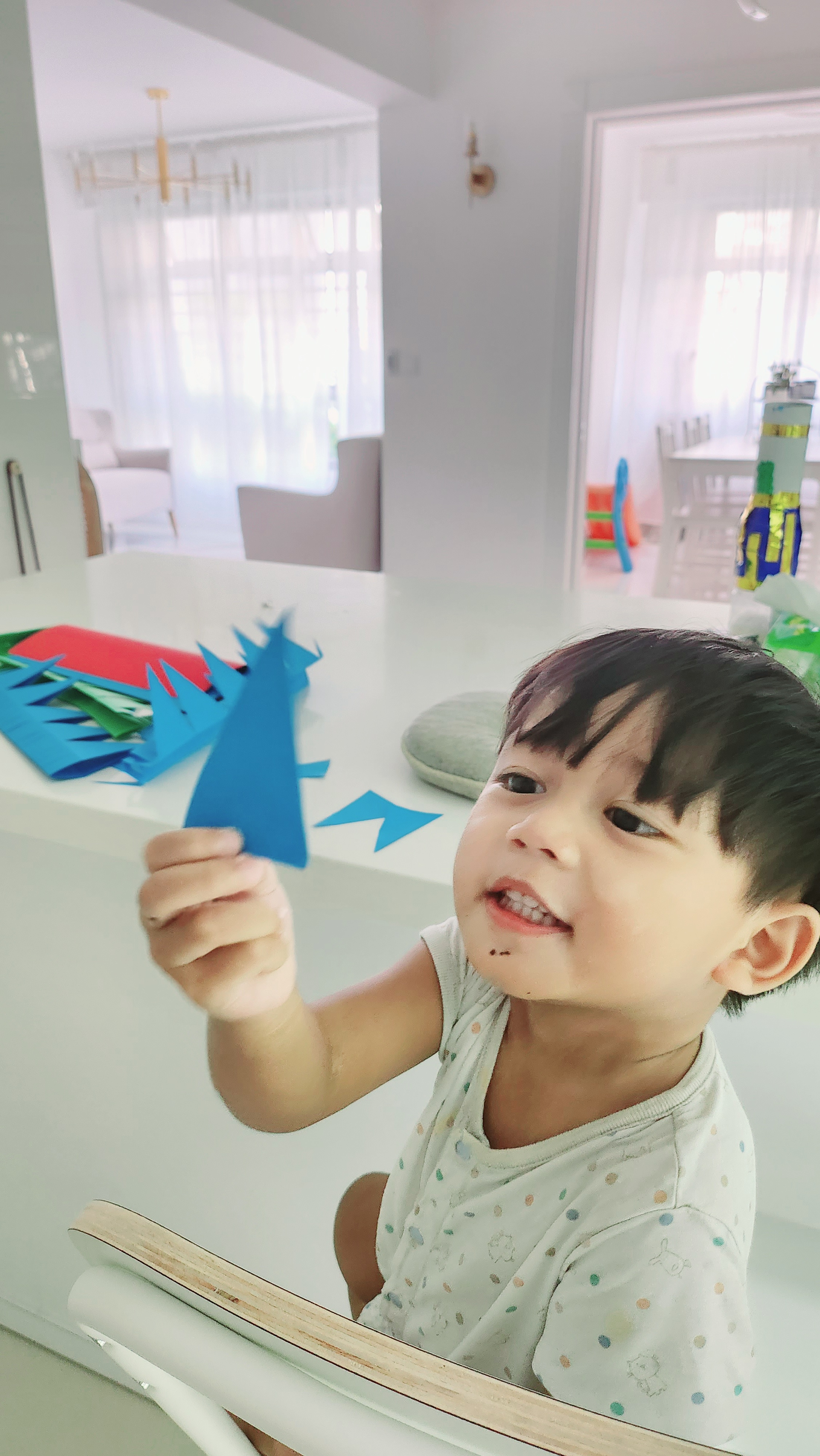 Weekend routine by PunggoHField - Child playing with paper airplane, child's hand holding blue paper airplane, child's face