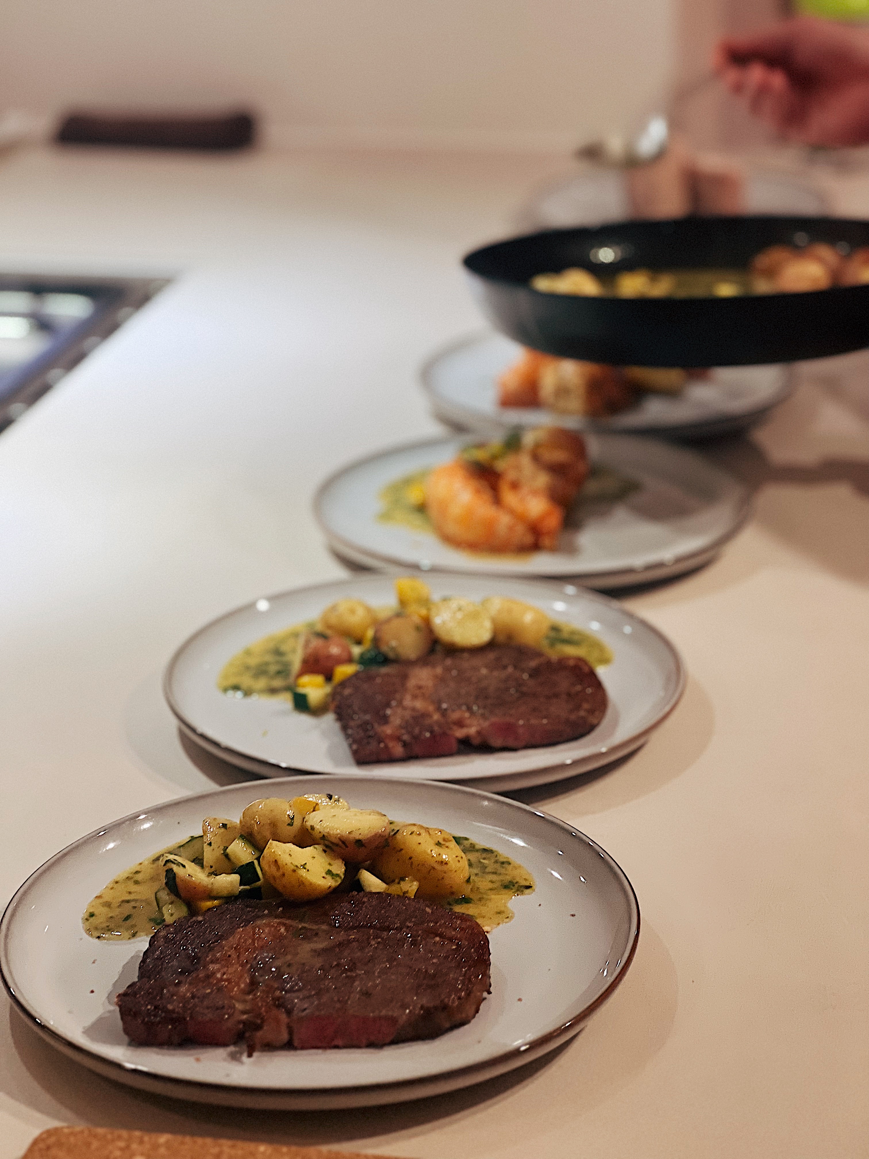 Whipping Up Meals on our Peninsula Stove - Grilled steak, roasted potatoes, garnished vegetables, creamy sauce, side dish